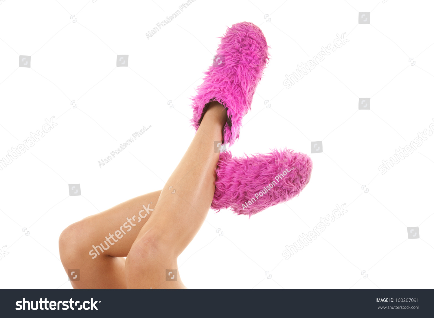 A Woman Holding Her Legs Up With Pink Fuzzy Slippers On Her Feet Stock