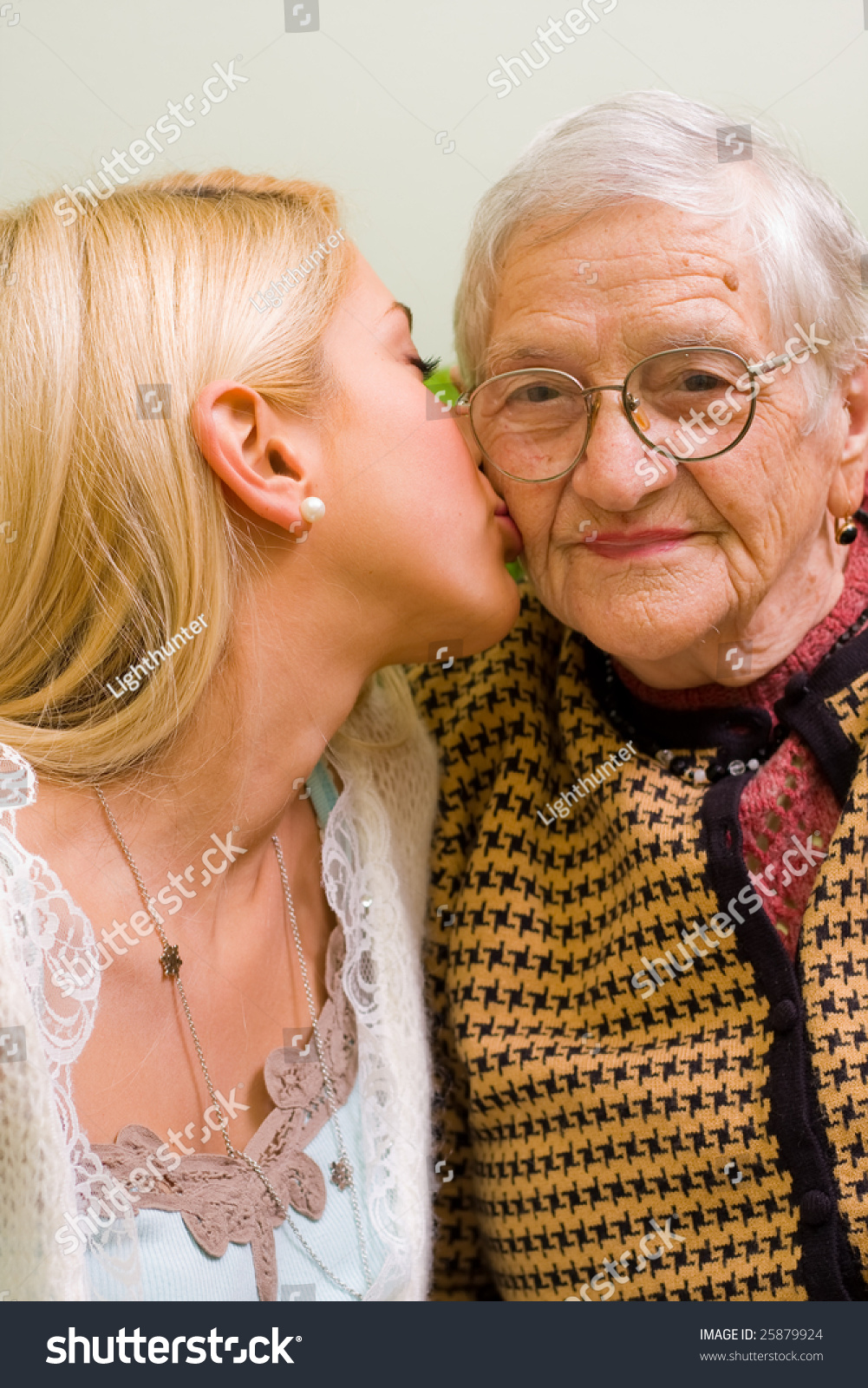 A Young Woman Kissing An Older One Focus On The Elderly Part Of A