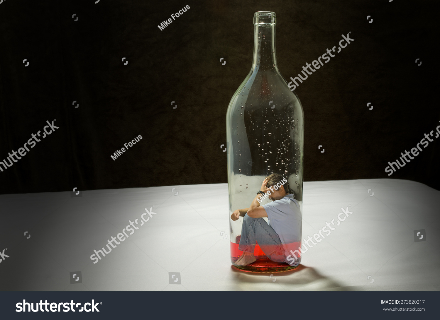 Addiction To Alcohol Depicted By A Man Trapped Inside A Bottle Of Booze