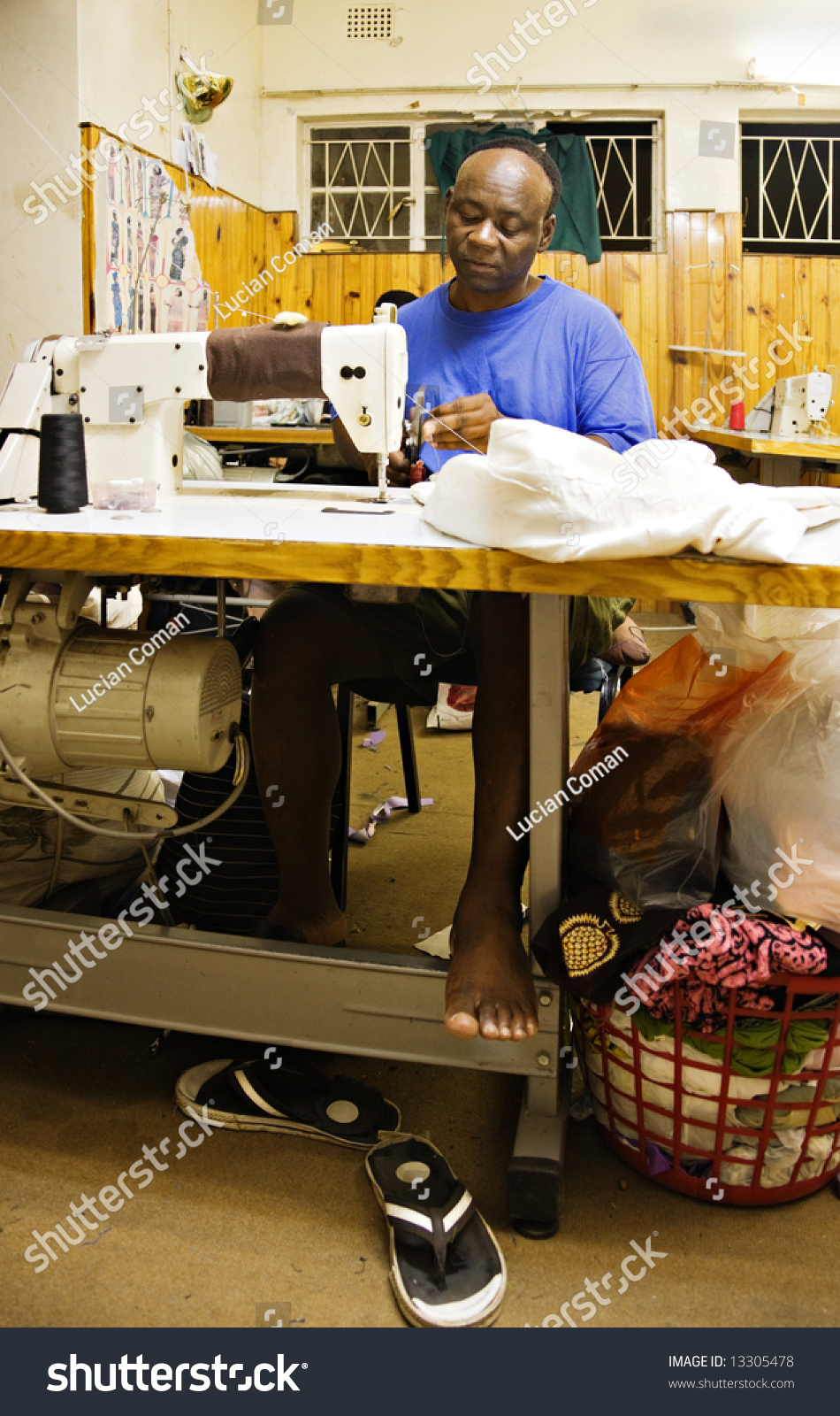 African Man Sewing In A Small Tailor Shop, Industrial Sewing Machine