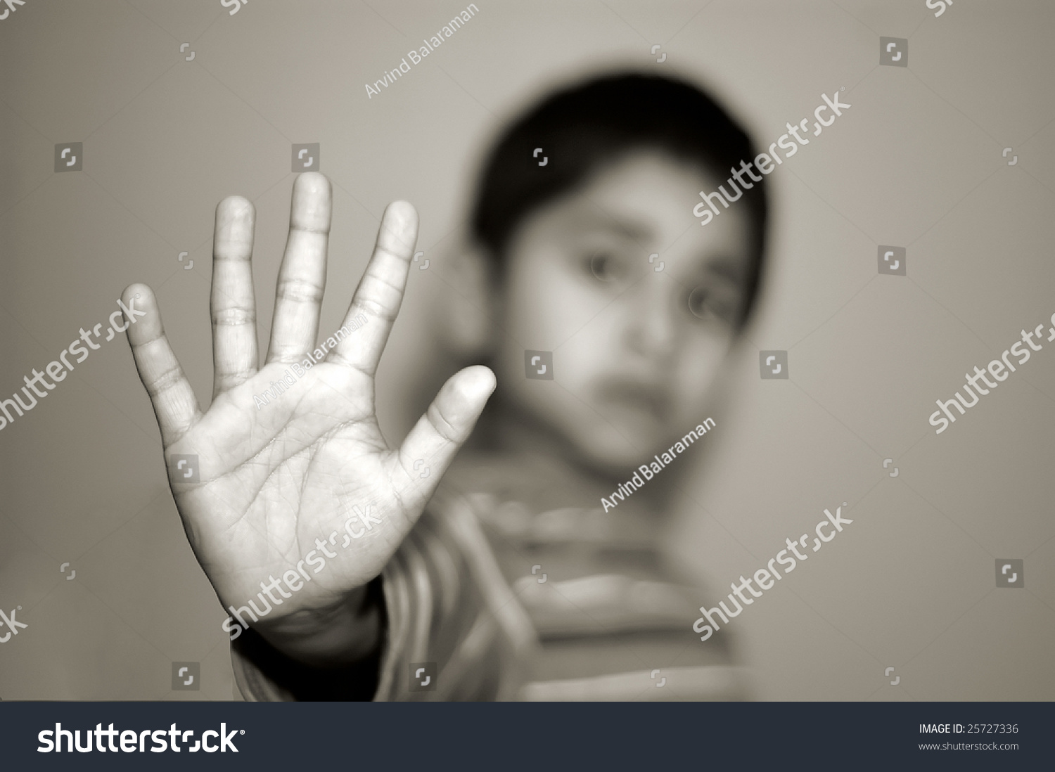 An Handsome Indian Kid Holding Out A An Handsome Indian Kid Holding A Stop Sign Stock Photo
