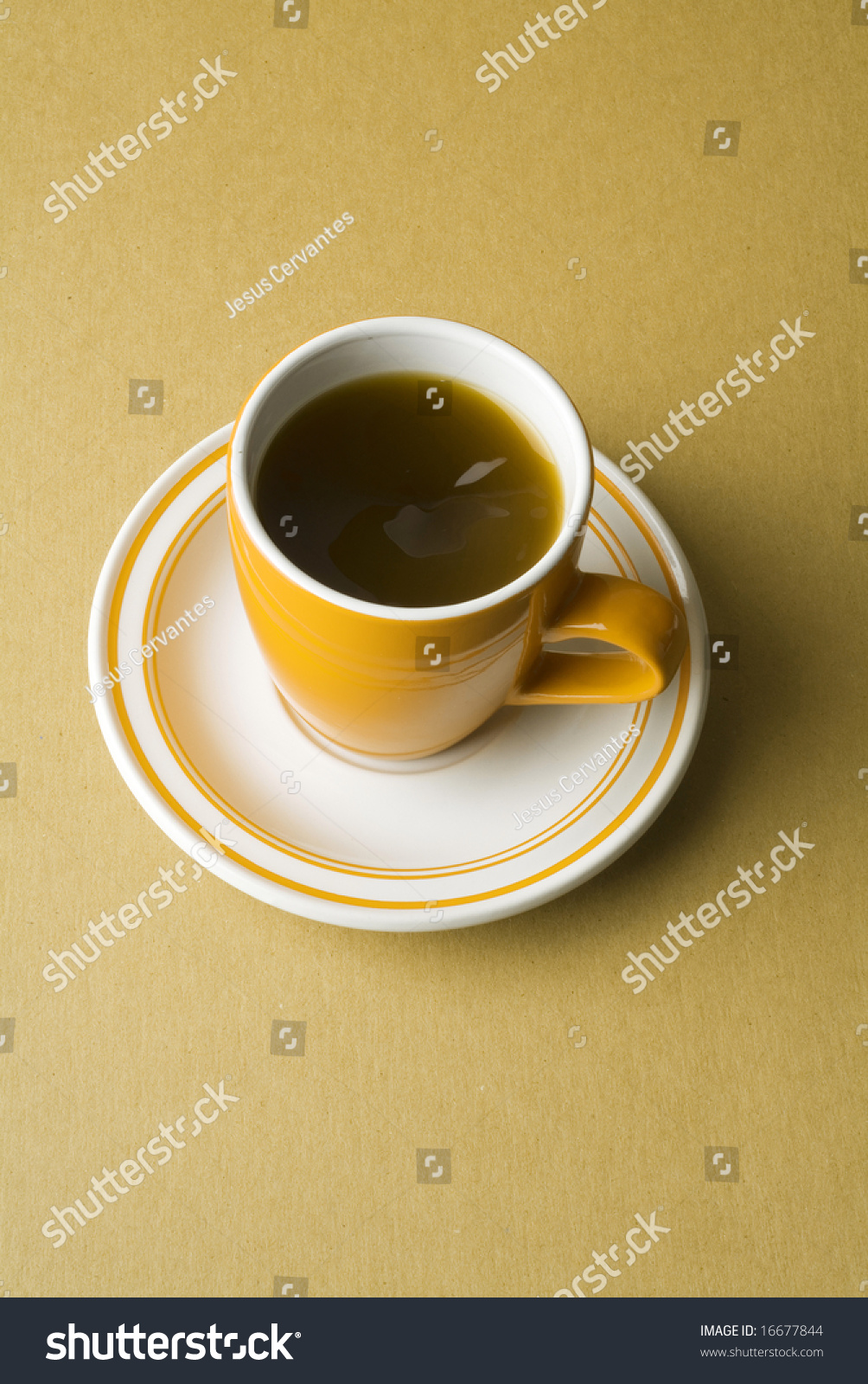 An orange coffee cup and plate An orange coffee cup and plate