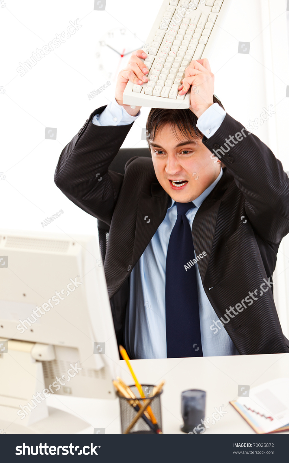 Angry Business Man Sitting At Office Desk And Destroying Computer Using