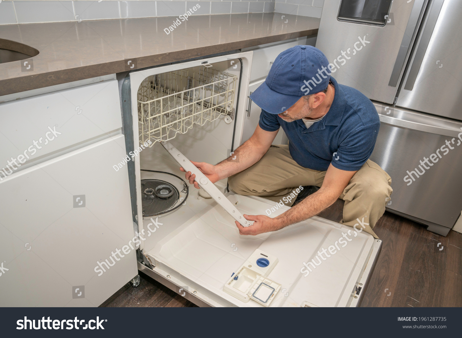 Appliance Repair Service Technician Performing Maintenance Stock Photo