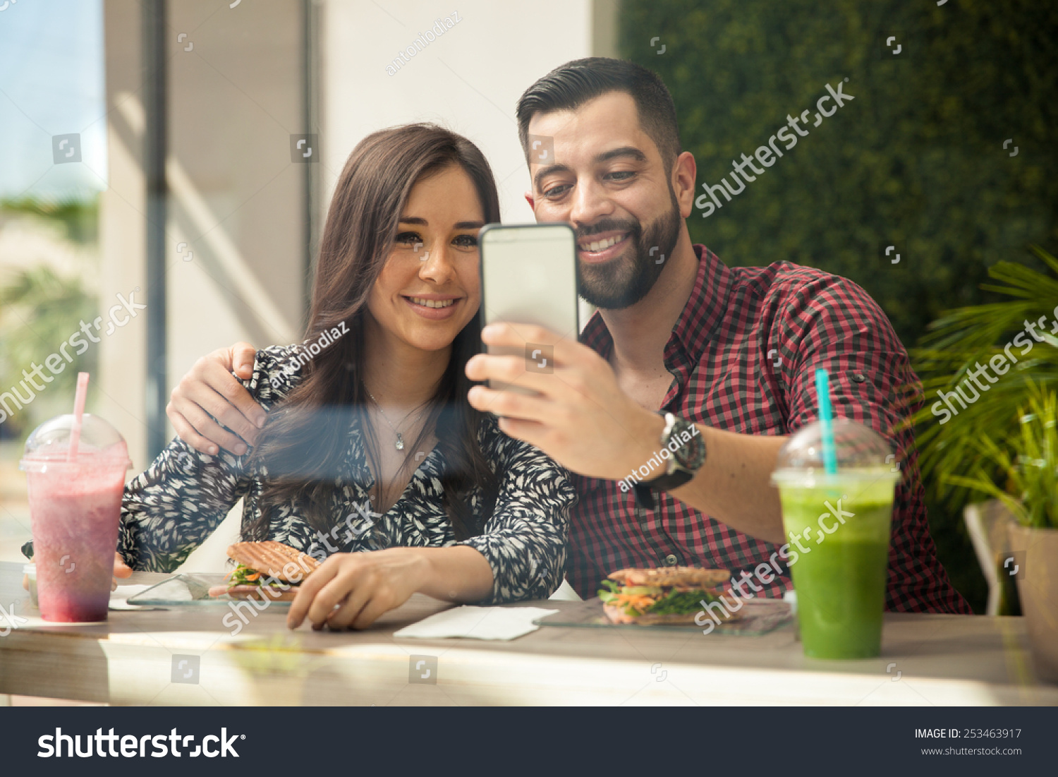 Attractive Young Hispanic Couple Taking A Selfie With A Smartphone While Eating Lunch 5889
