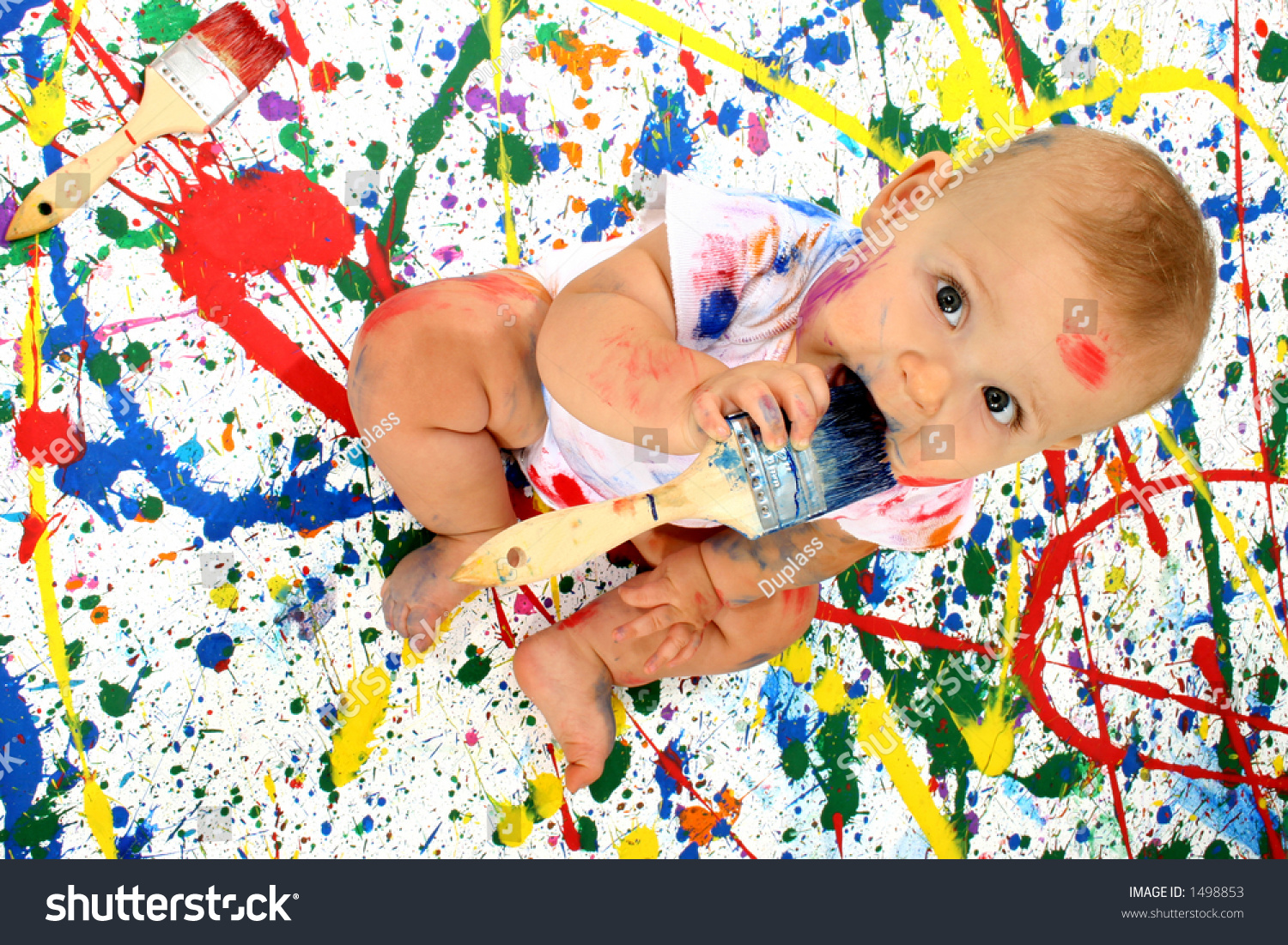 Beautiful Baby Covered In Bright Paint With Paint Brush Stock Photo