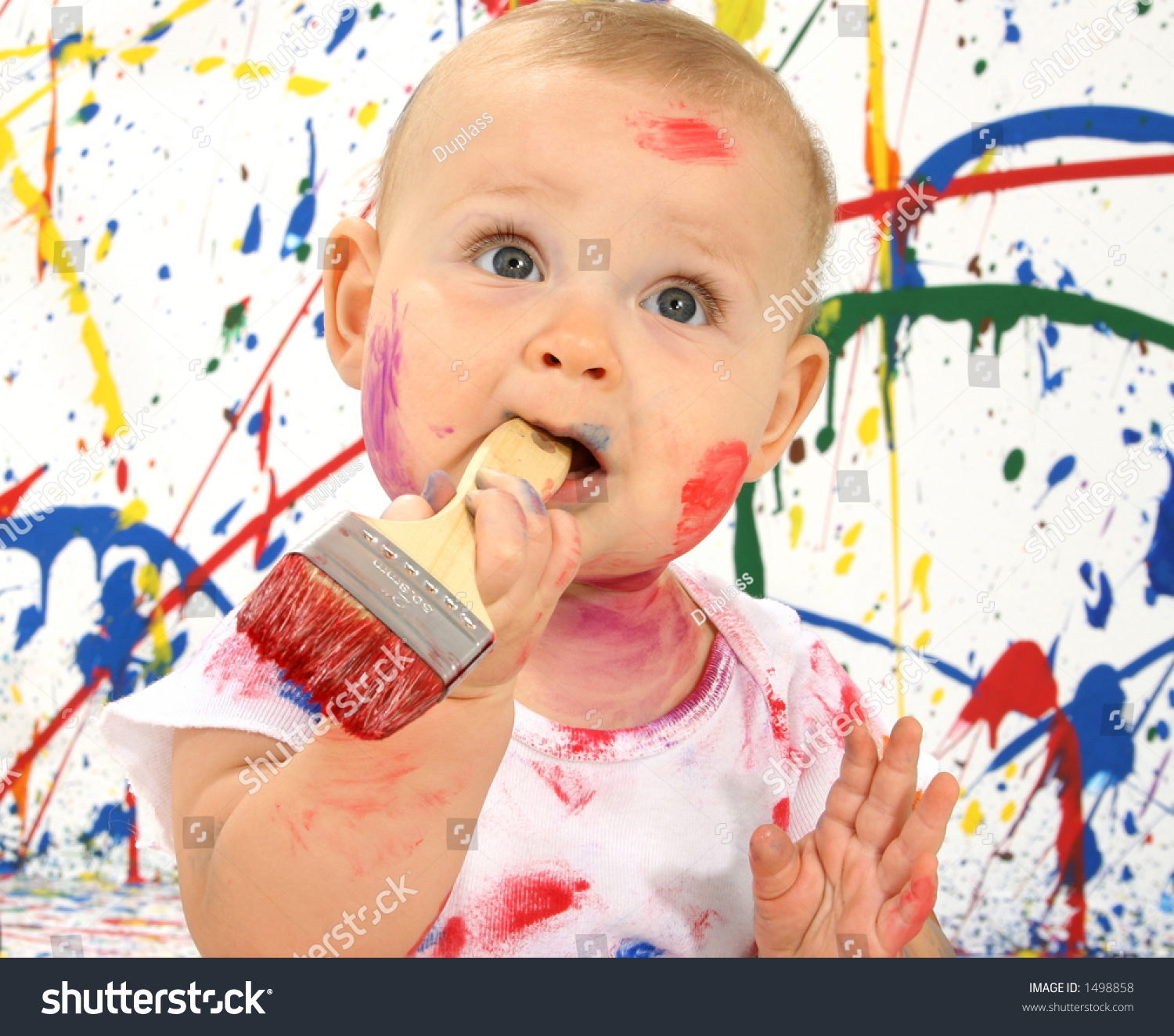 Beautiful Baby Covered In Bright Paint With Paint Brush In Mouth Stock