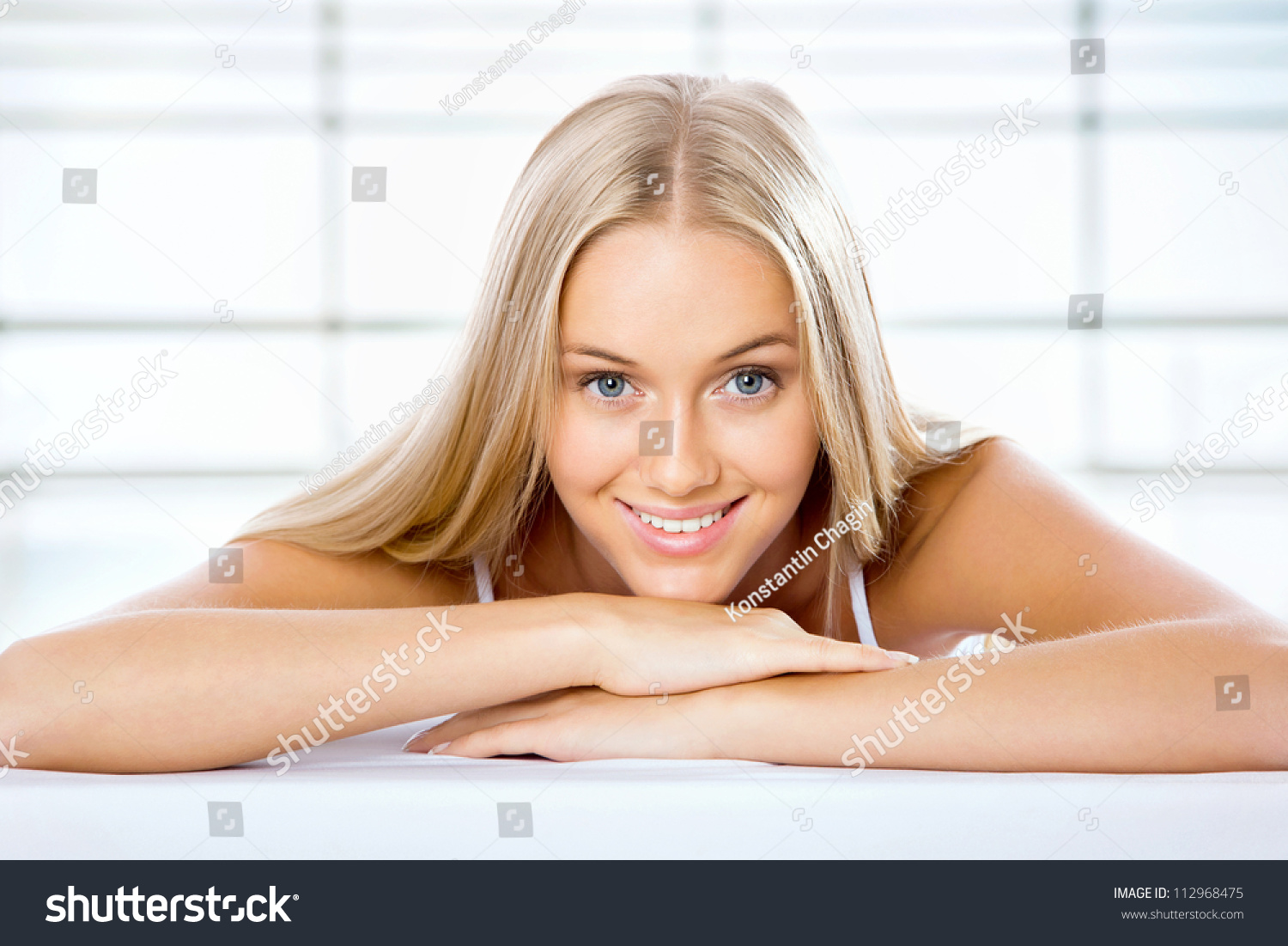 Beautiful Blonde Woman Lying On The Bed And Smiling Stock Photo