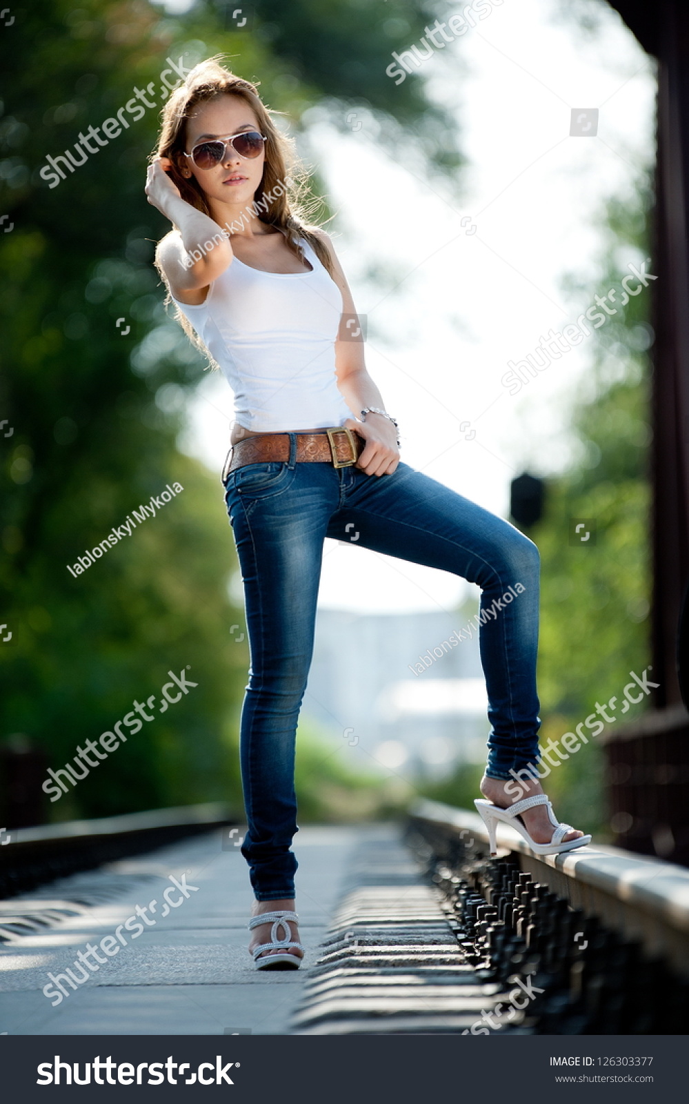 Beautiful Brunette Girl In Jeans And A T Shirt Posing On Railroad