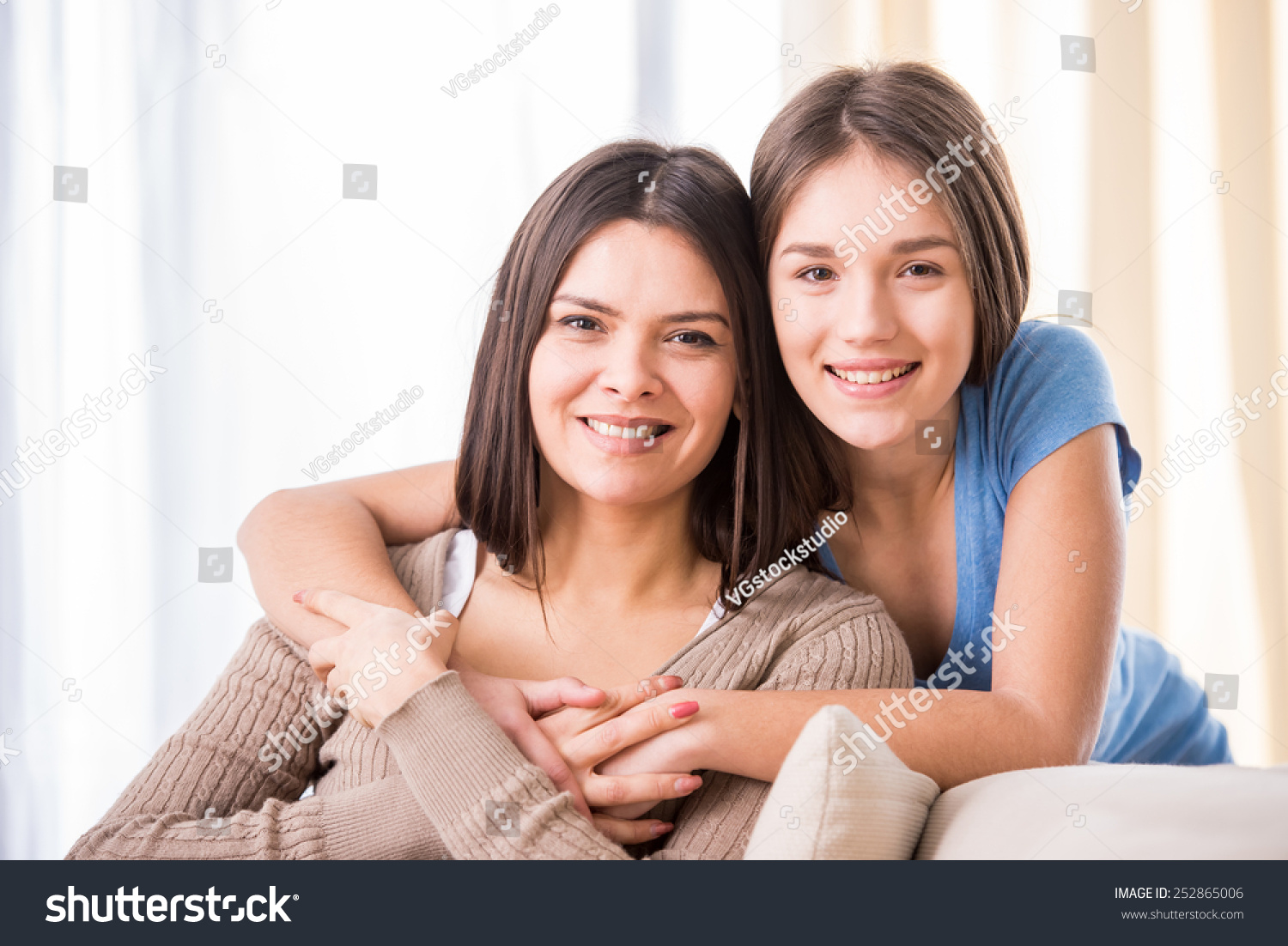 Beautiful Mother And Her Cute Daughter Smiling And Posing At Home