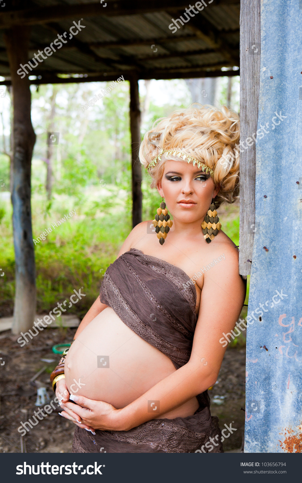 Beautiful Pregnant Woman With Long Curly Blonde Hair And A Very Large Protruding Belly Standing 3264