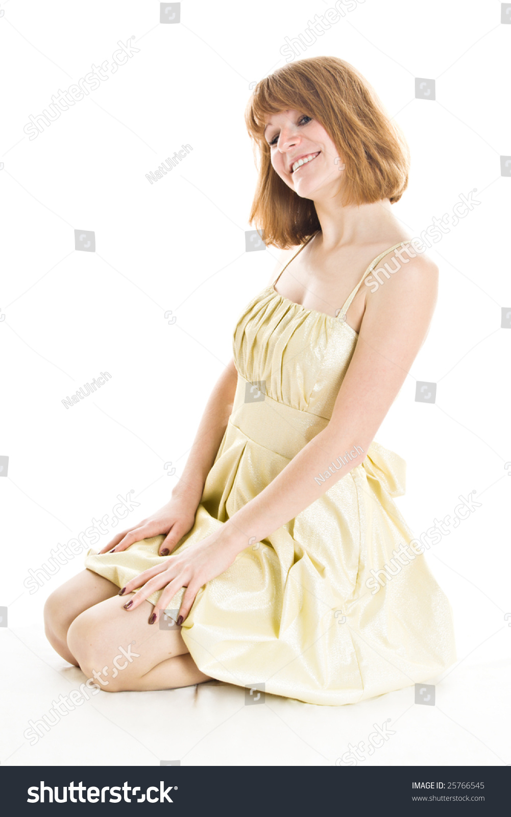 Beautiful Woman In Beige Dress Sitting On Knees Isolated On White