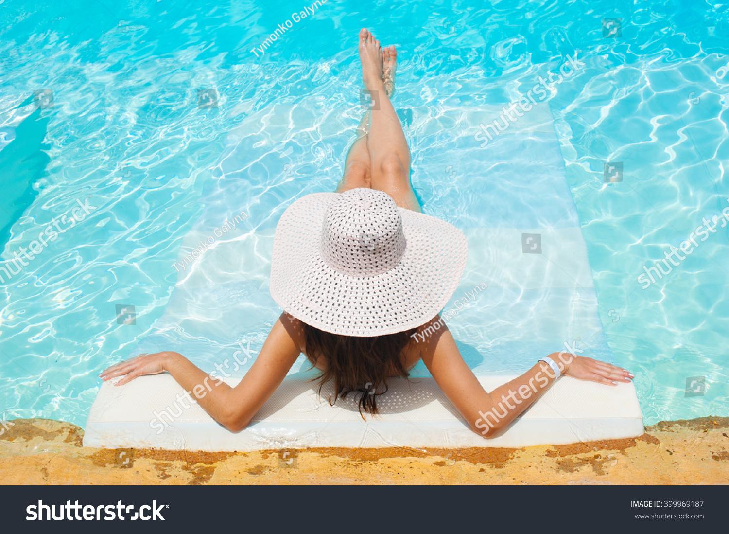 beautiful woman white hat and bikini lying in a pool beautiful woman white hat and bikini lying in a pool