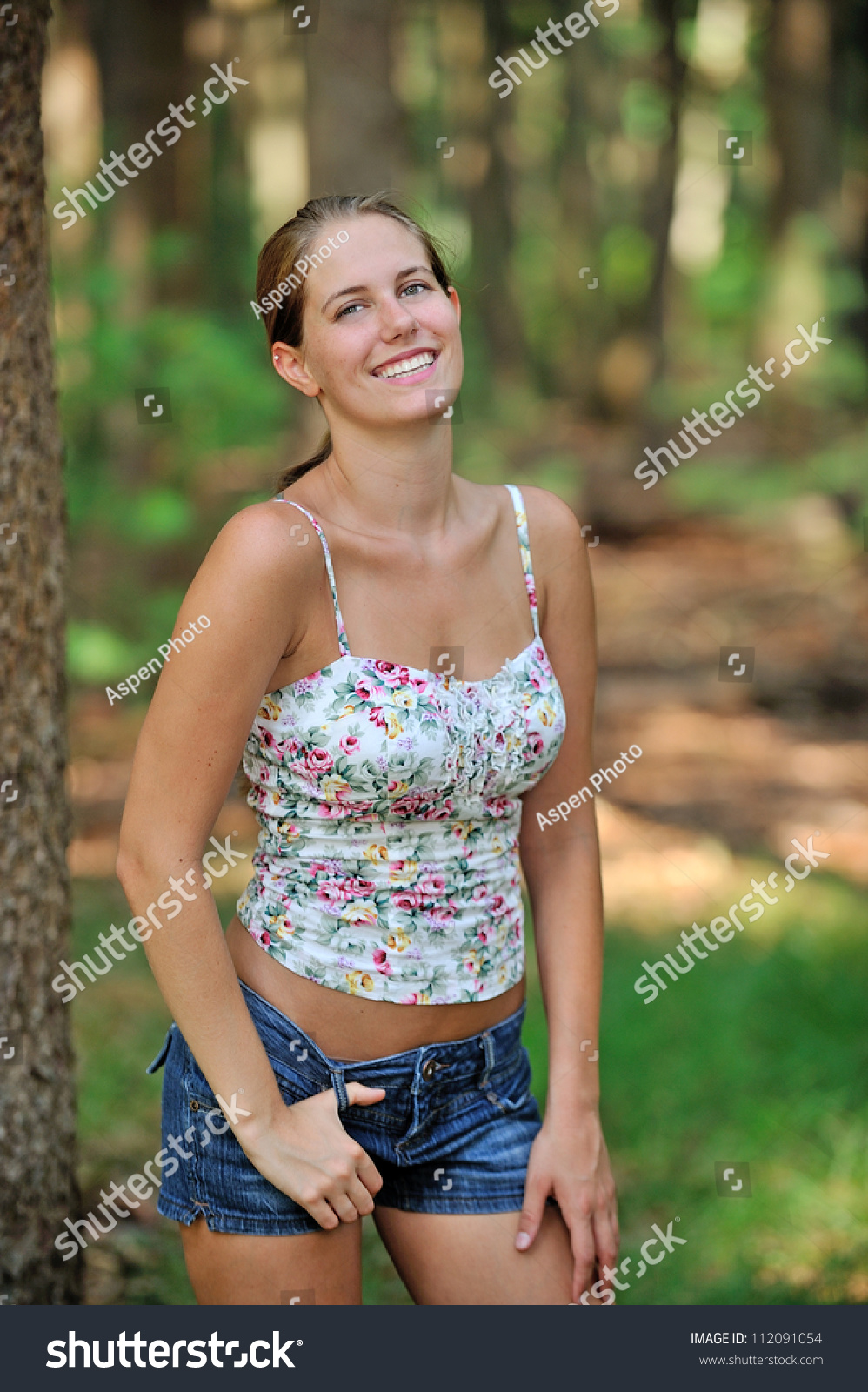 Beautiful Young Caucasian Woman In Tank Top And Denim Shorts Smiling In Forest Clearing Stock 4082