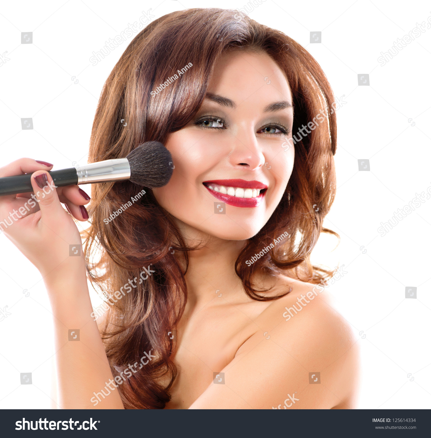 Portrait Of A Beautiful Brunette Woman Applying Red Lipstick On Her