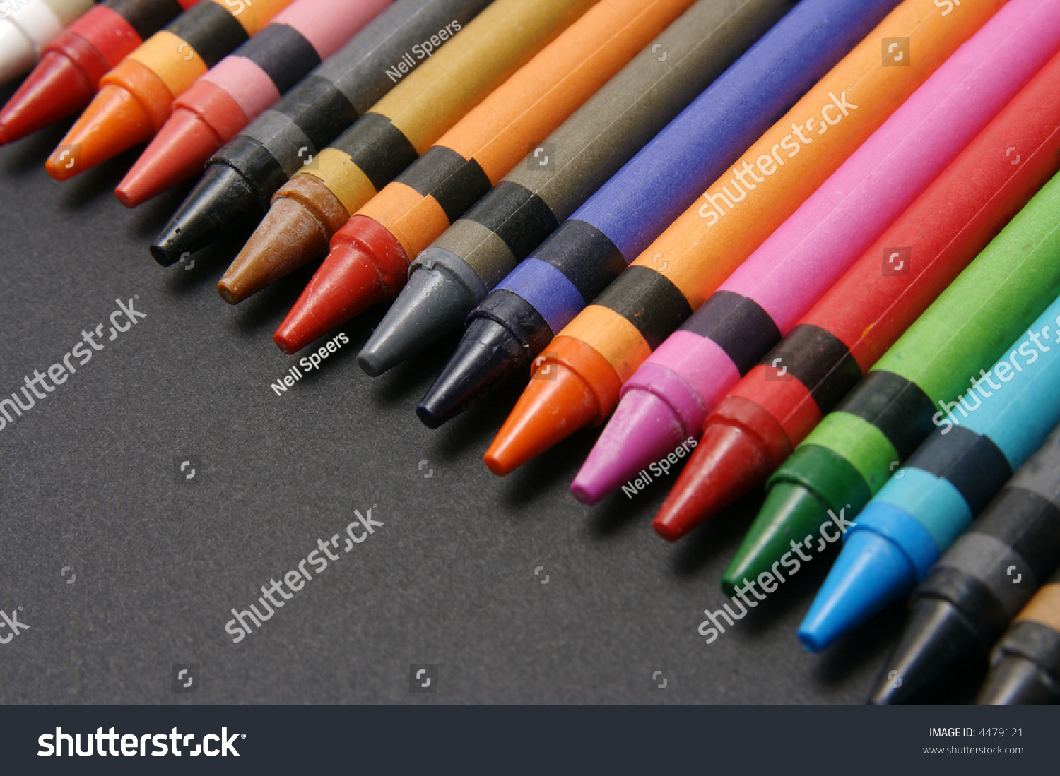 Brightly Colored Crayons Lined Up On Black Paper. Stock Photo 4479121