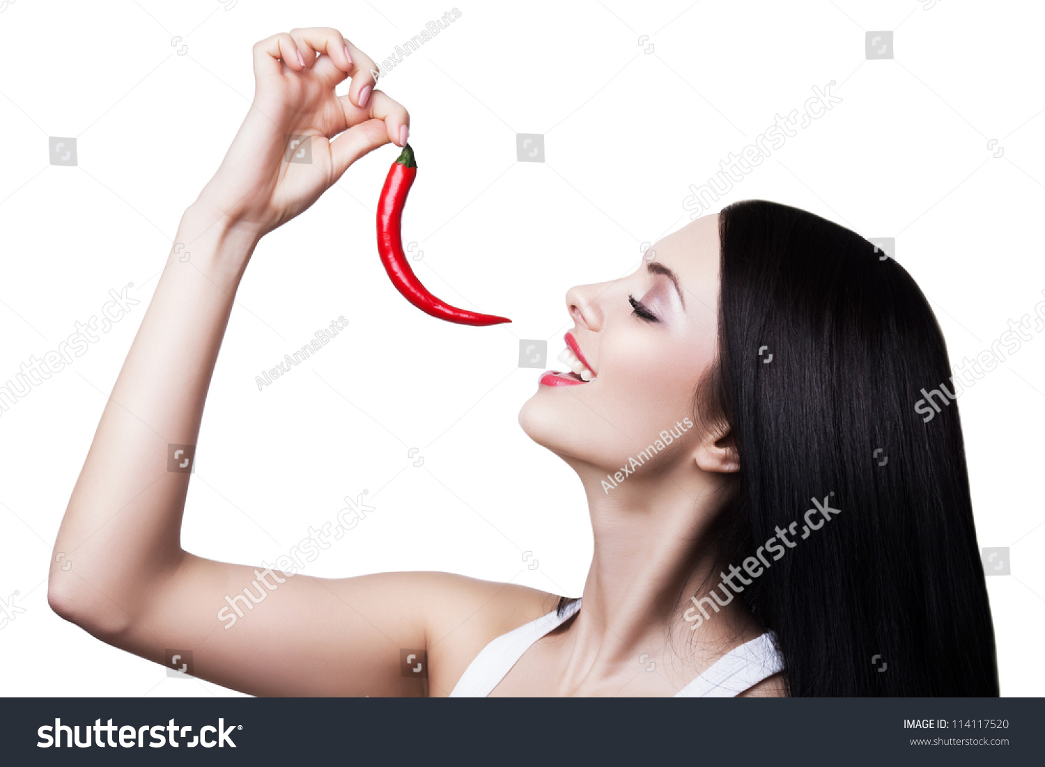 Brunette Woman Eating Chili Pepper On White Background Stock Photo