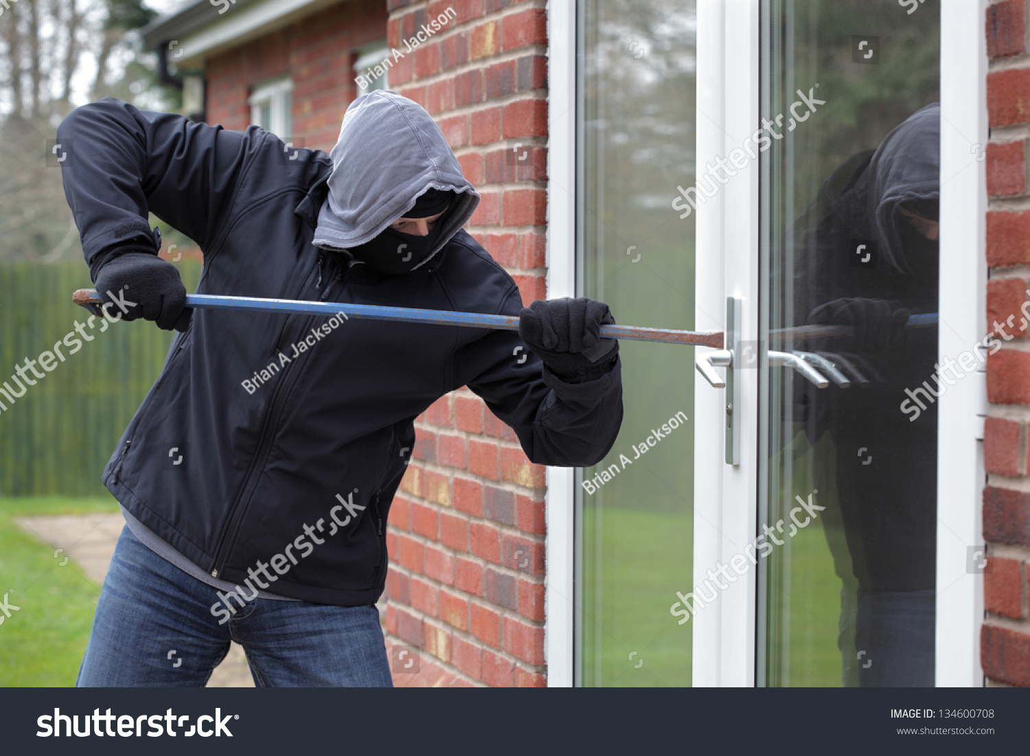Burglar Breaking Into A House Window With A Crowbar Stock