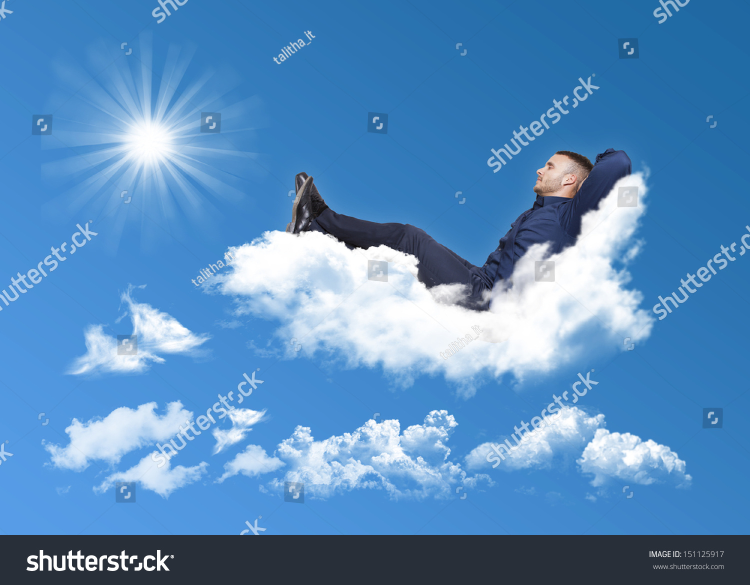 Businessman Relaxing On A Cloud In A Blue Sky With Sun Stock Photo 