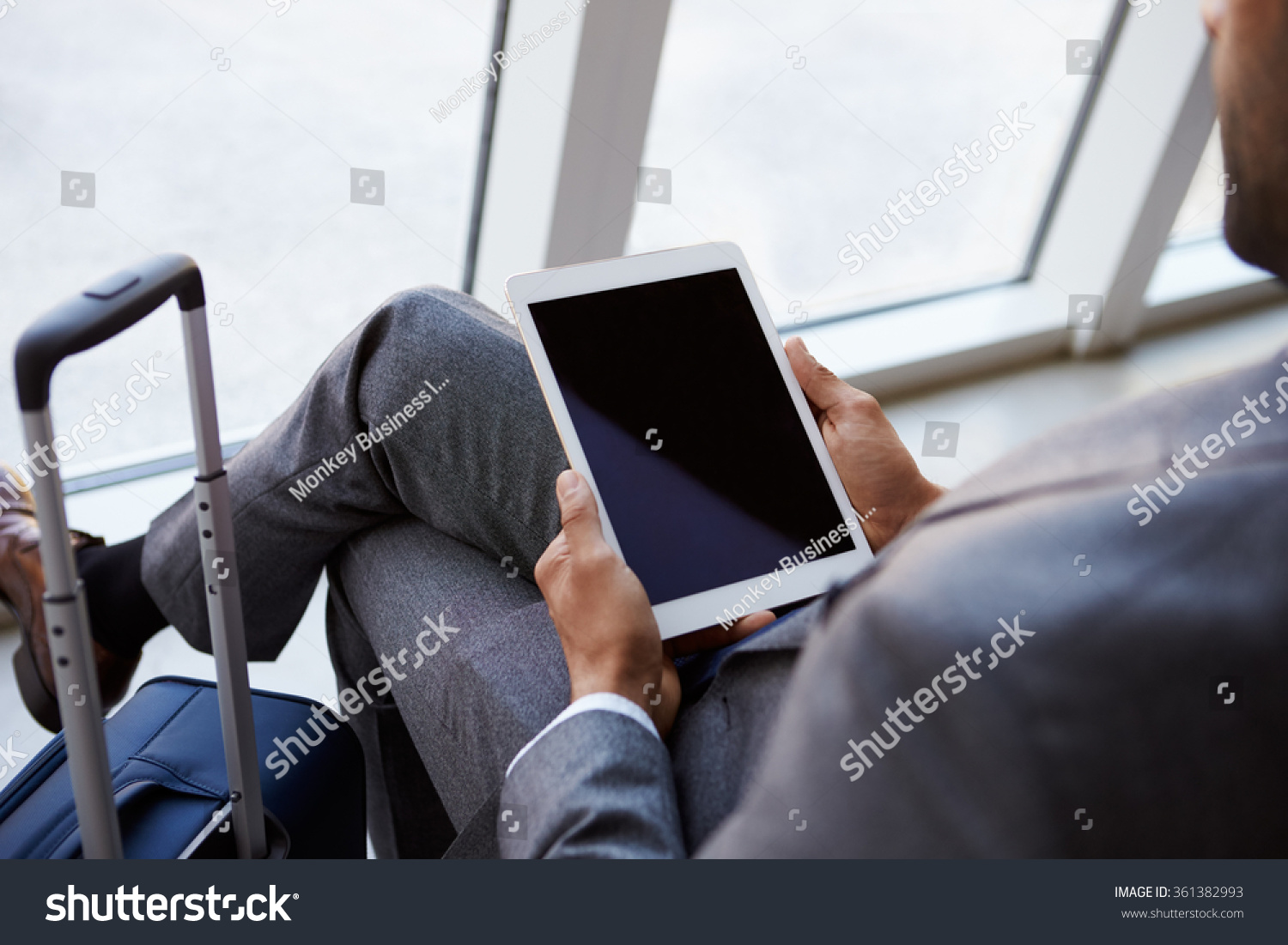 Businessman Using Digital Tablet In Airport Departure Lounge Businessman Using Digital Tablet In Airport Departure Lounge