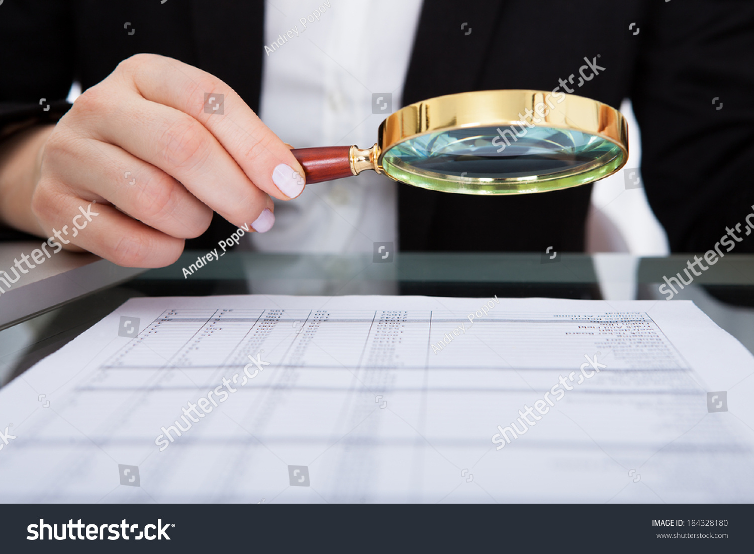 Businesswoman Looking Document Through Magnifying Glass Stock Photo