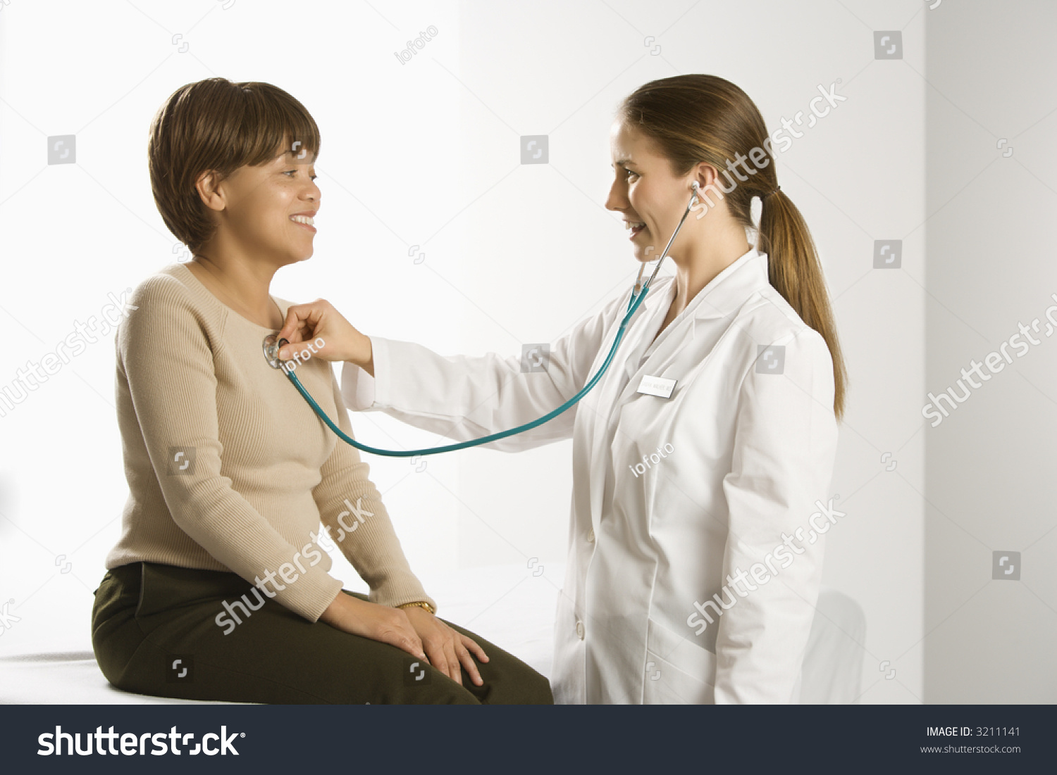 Caucasian Mid Adult Female Doctor Examining African American Middle