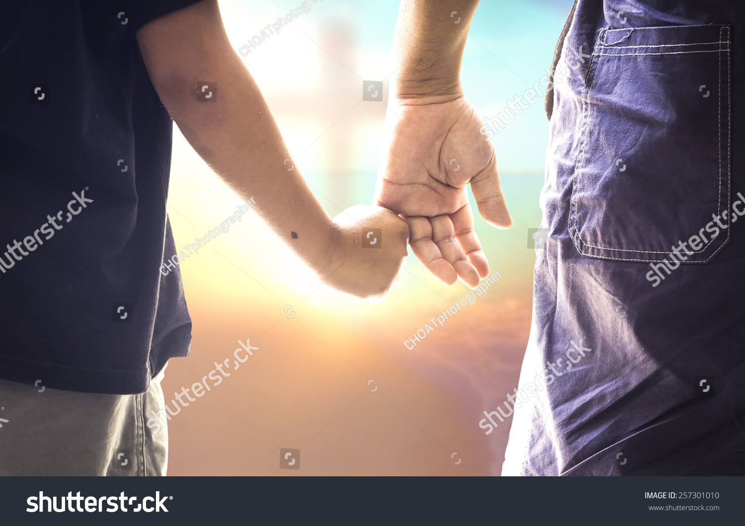 Child hand holding father finger on blurred the cross on sunset background Health Care Fathers Day Responsibility Worship Forgiveness Repentance Reconcile Adoration Glorify Redeemer concept Child hand holding father finger on blurred the cross on sunset background Health Care Fathers Day Responsibility Worship Forgiveness Repentance Reconcile Adoration Glorify Redeemer concept