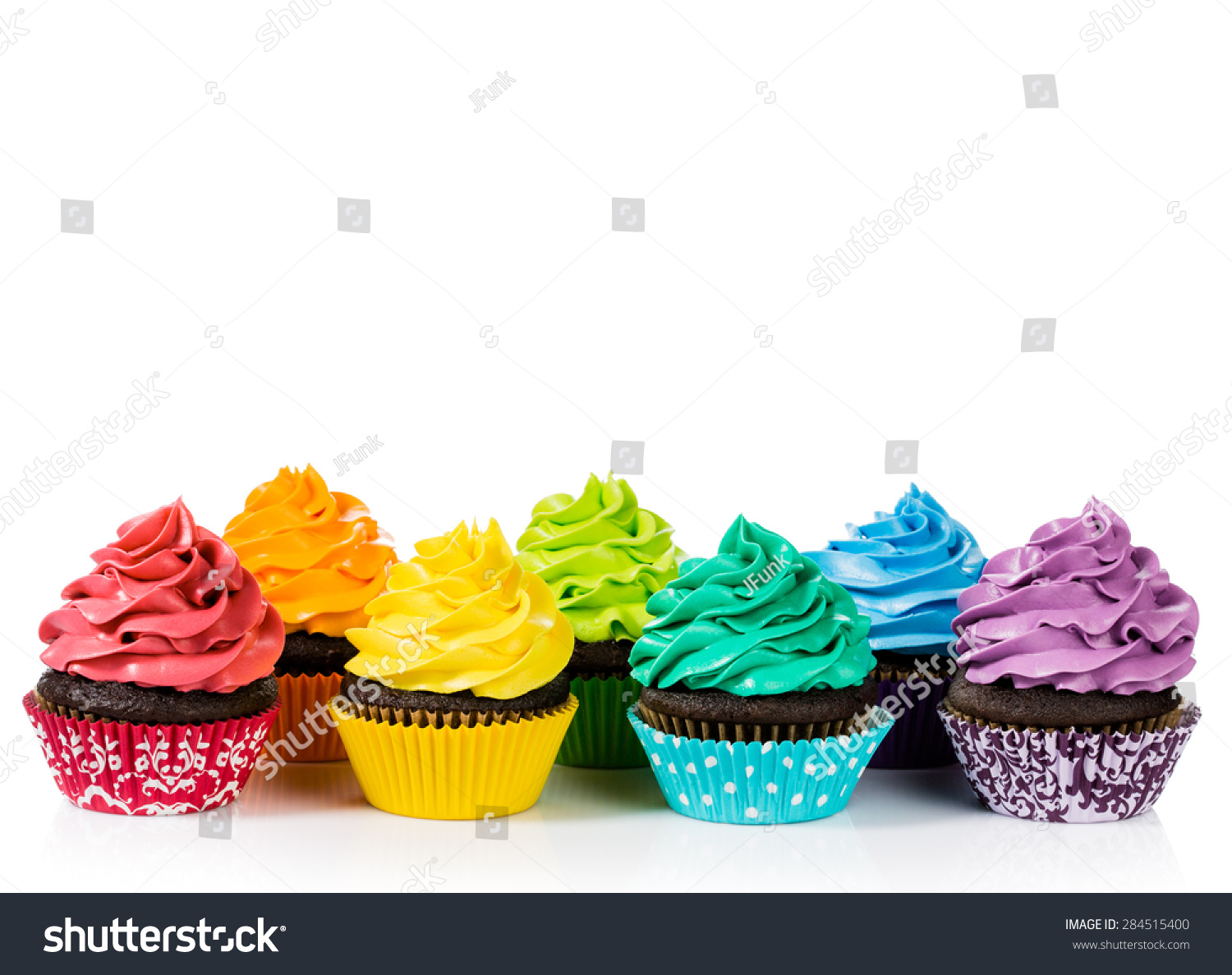 Chocolate cupcakes in rows with colorful icing on a white background Chocolate cupcakes in rows with colorful icing on a white background