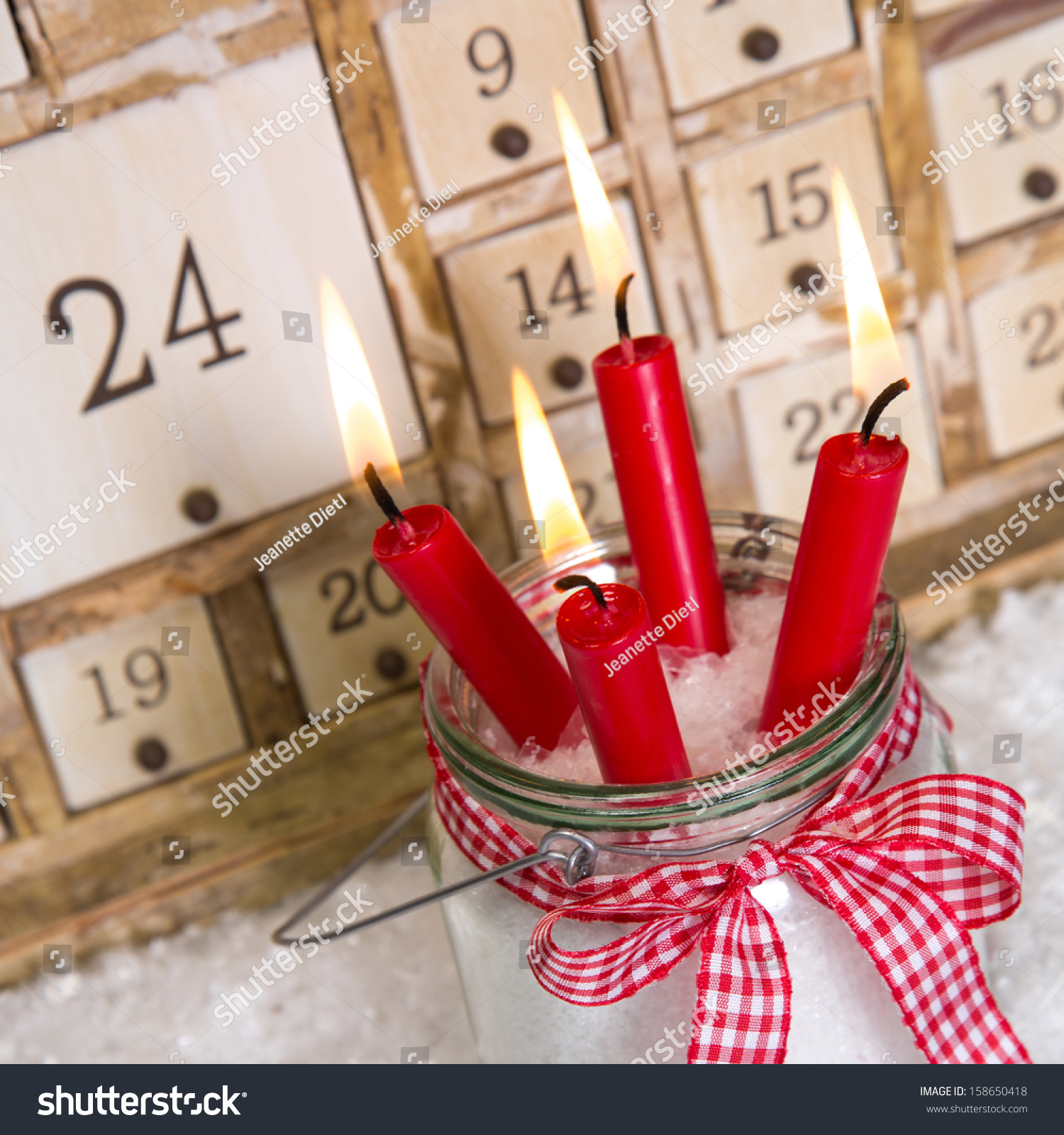 Christmas Eve: Four Red Burning Candles With A Shabby White Advent Calendar Background Stock