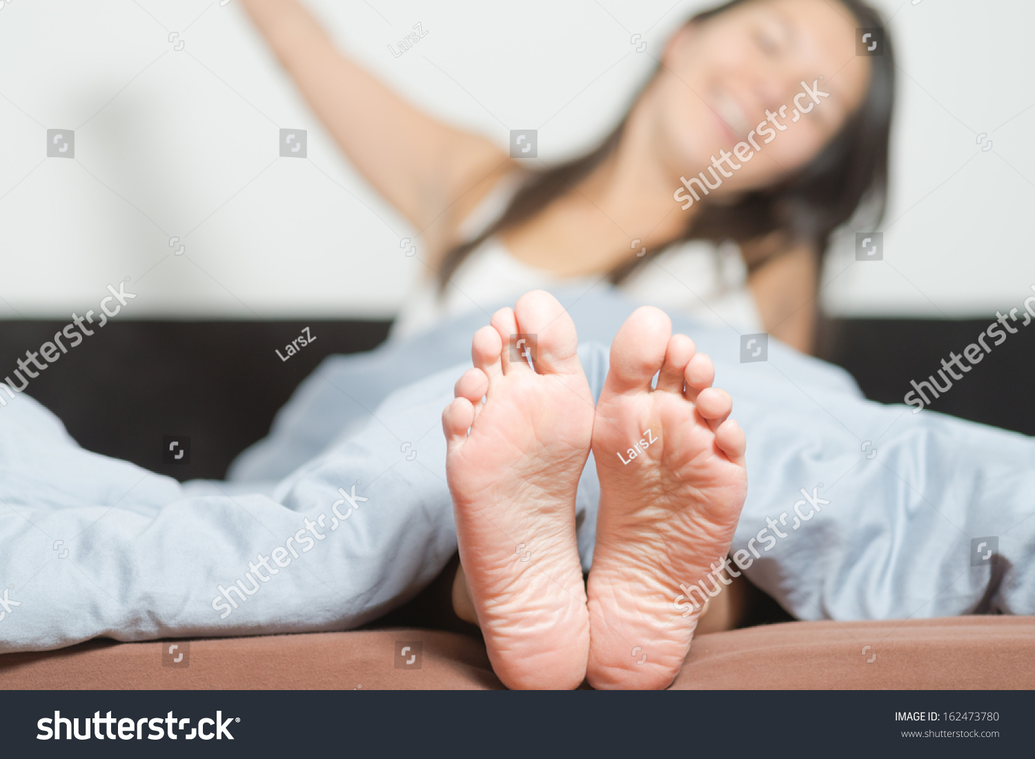 Close Up Of The Cute Crinkled Soles Of Female Feet Belonging To A Smiling Playful Woman Relaxing 