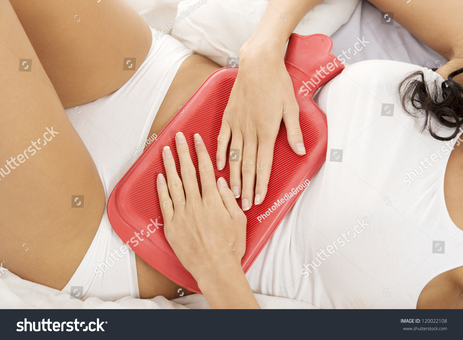 Close Up Of Woman Belly With Hot Water Bottle In Bed Stock Photo