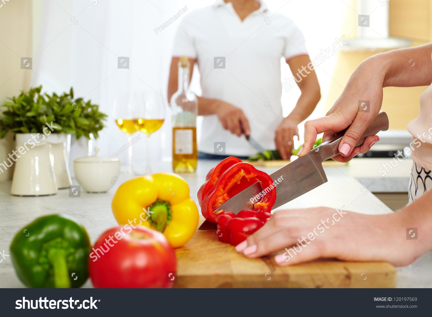 Close Up Of Young Female Cutting Red Pepper In The Kitchen