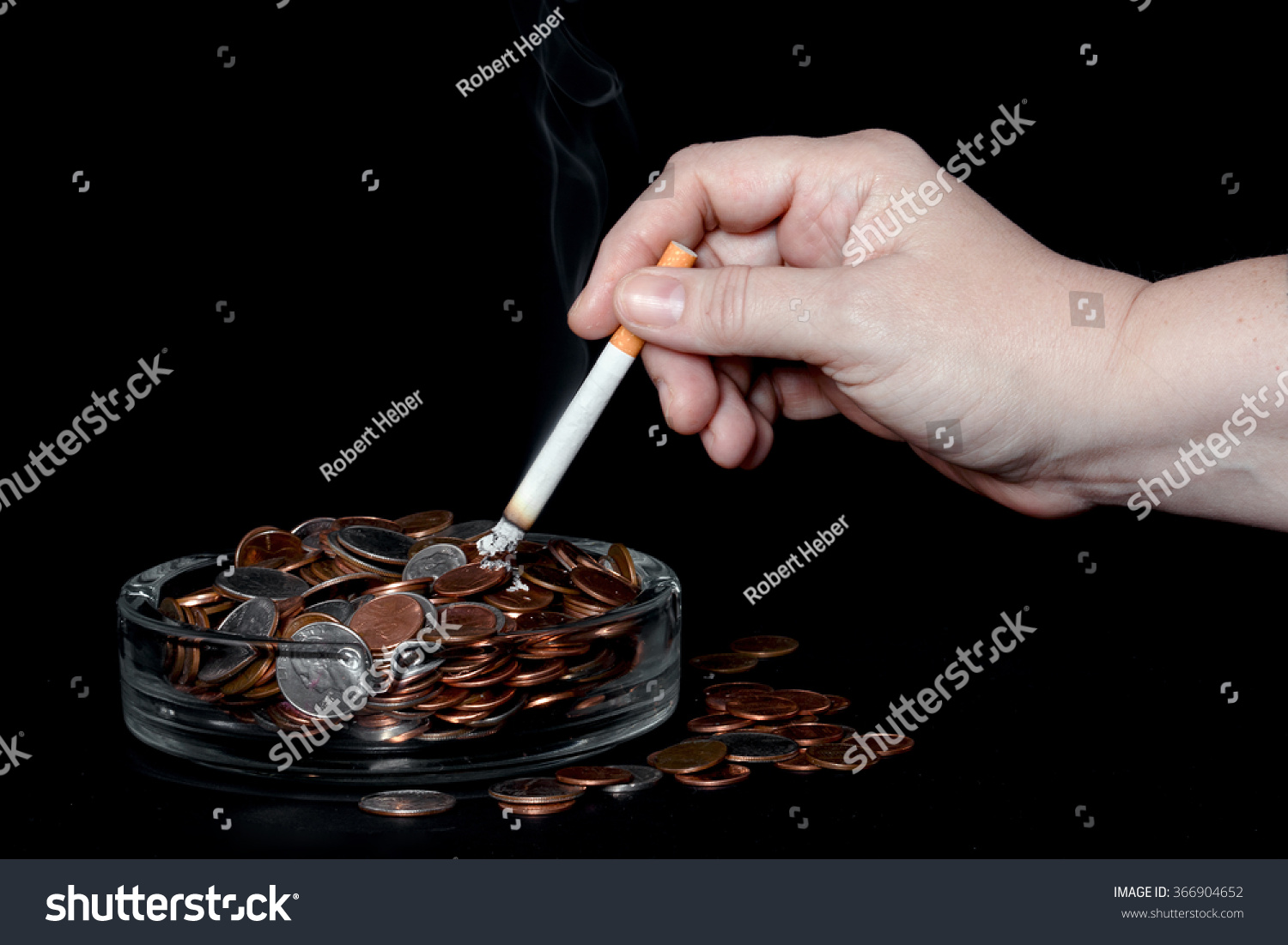 Closeup Of A Hand Holding A Lit Cigarette Over A Glass A