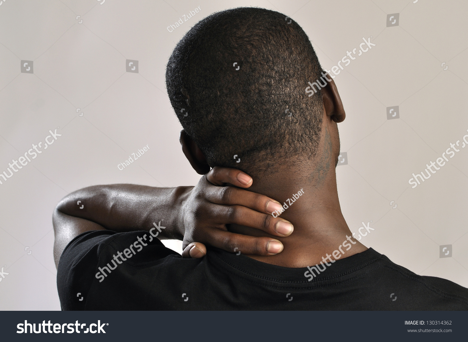 Closeup Of Man Rubbing His Neck With Hand As He Aches With Pain