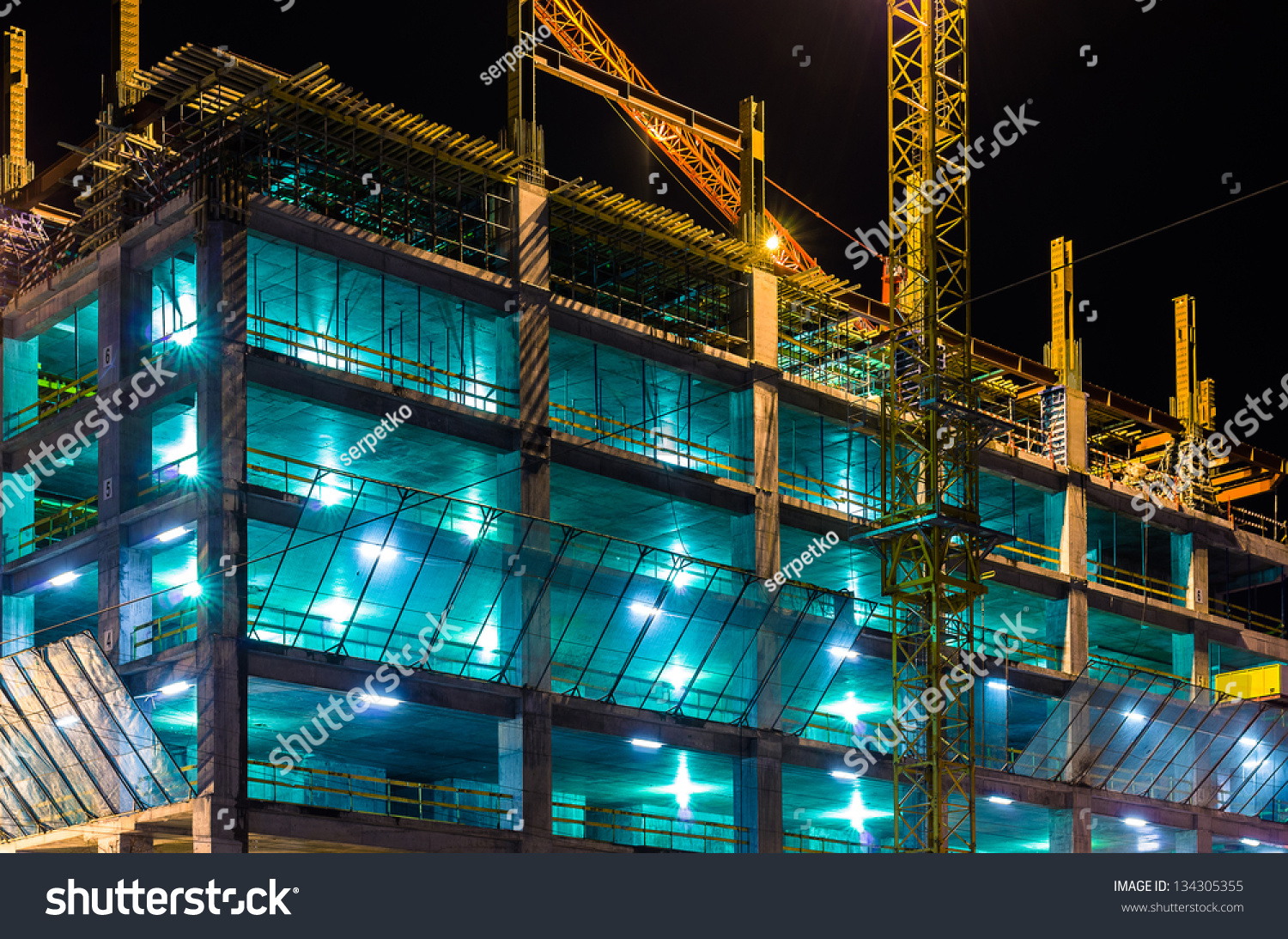 Construction At Night With Lights Against The Dark Sky Stock Photo