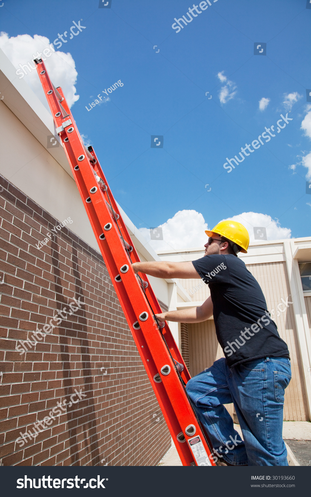 Construction Worker Climbing Up A Ladder To The Roof Of A Building