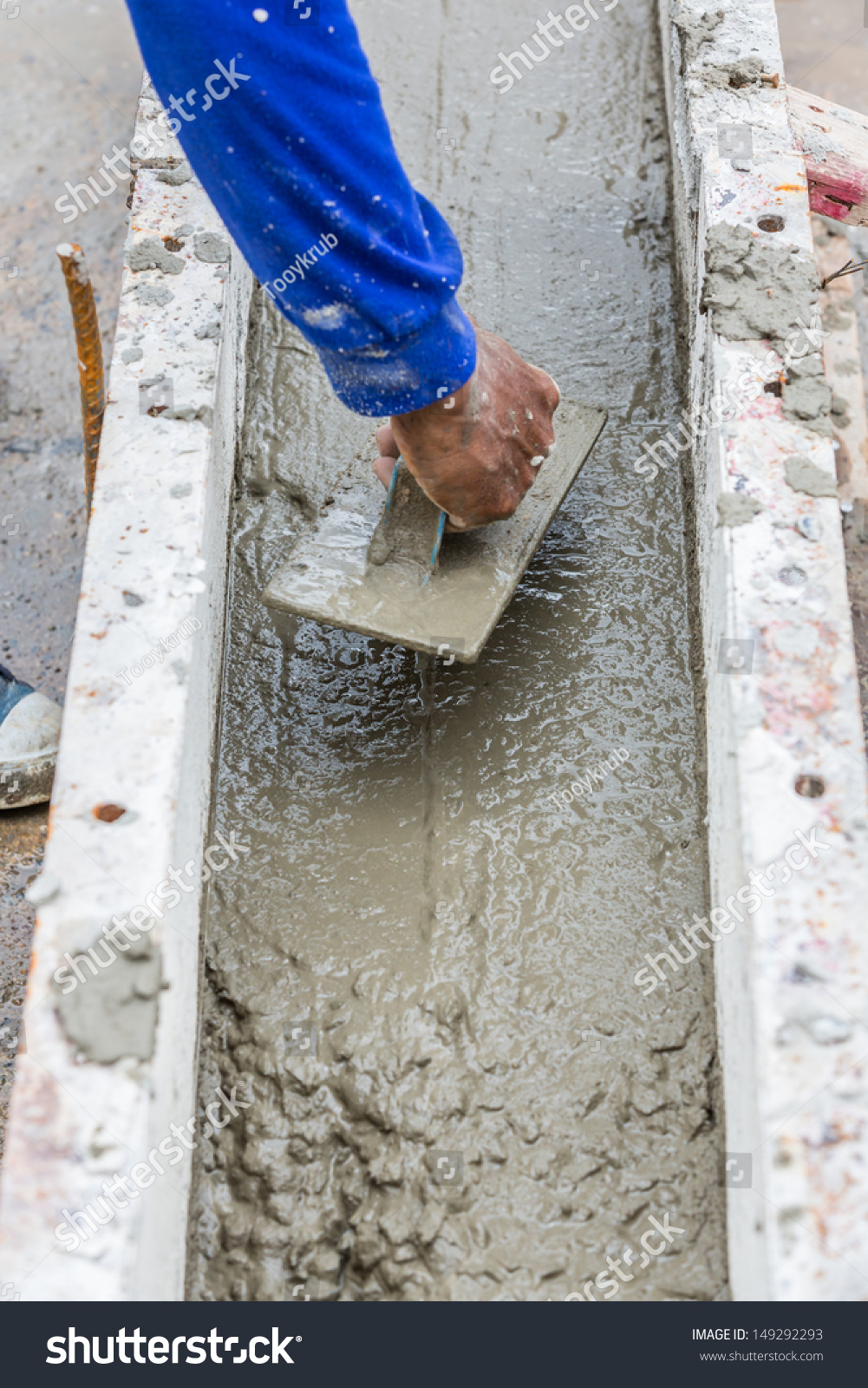 Construction Worker Spreading Wet Concrete On The Beam Casting Stock