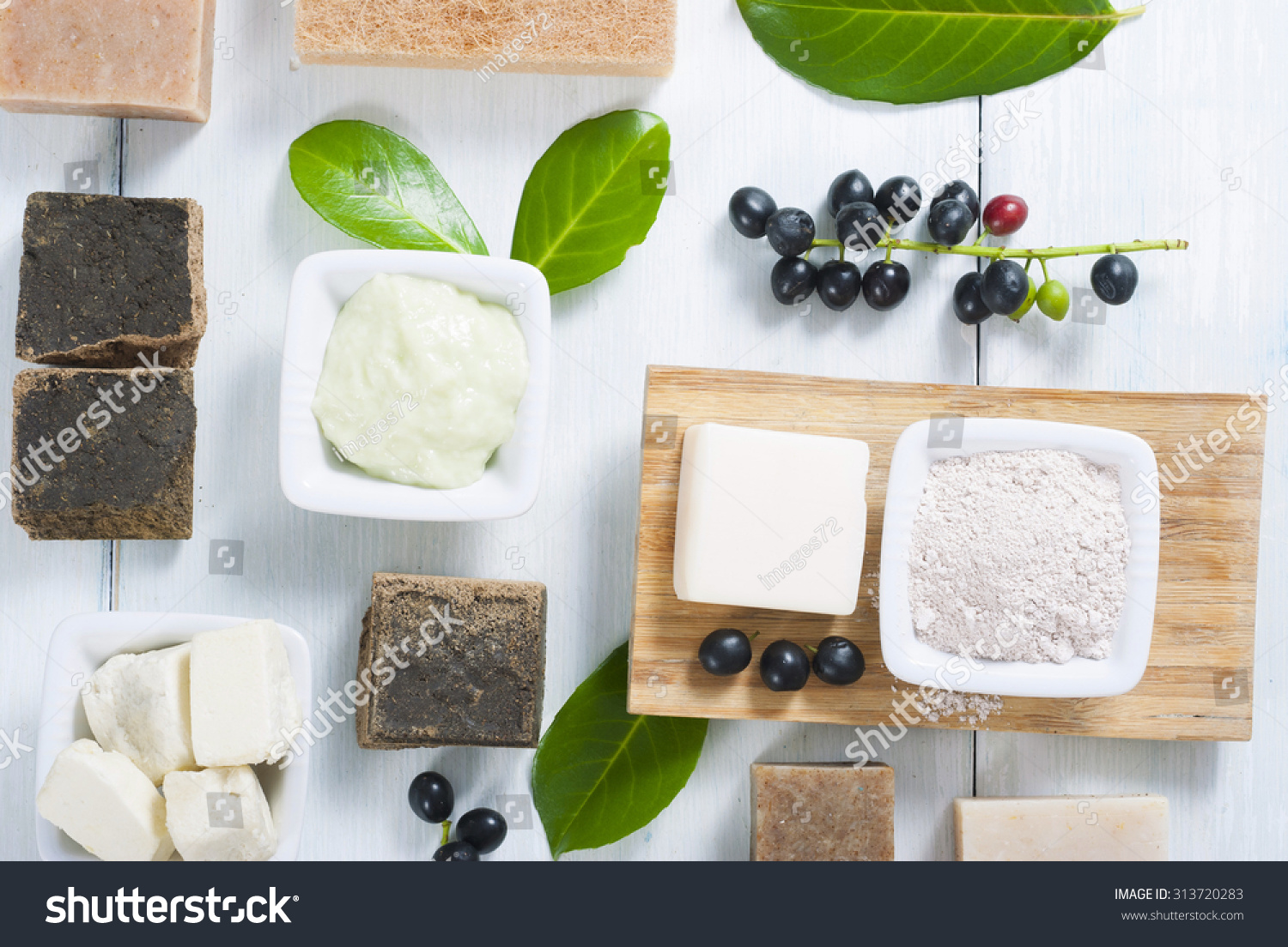 cosmetic clay soaps henna blocks sponge and moisturizer on white wood table cosmetic clay soaps henna blocks sponge and moisturizer on white wood table