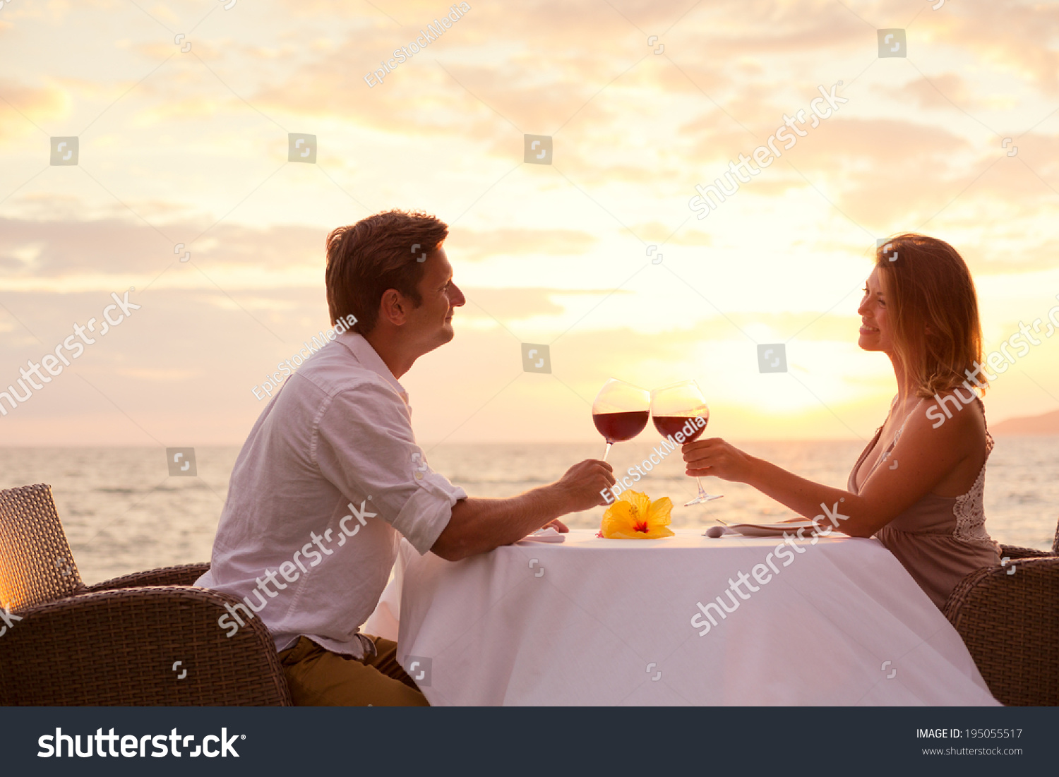 Couple Sharing Romantic Sunset Dinner On The Beach Stock Photo