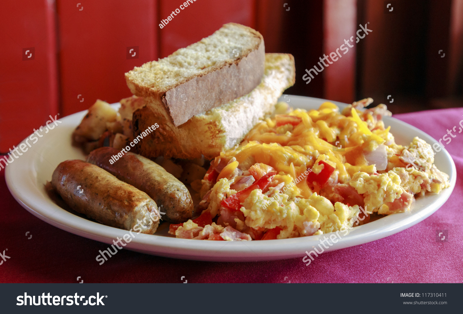 Delicious Scrambled Eggs With Cheese, Sausage, Potatoes And Toast For 