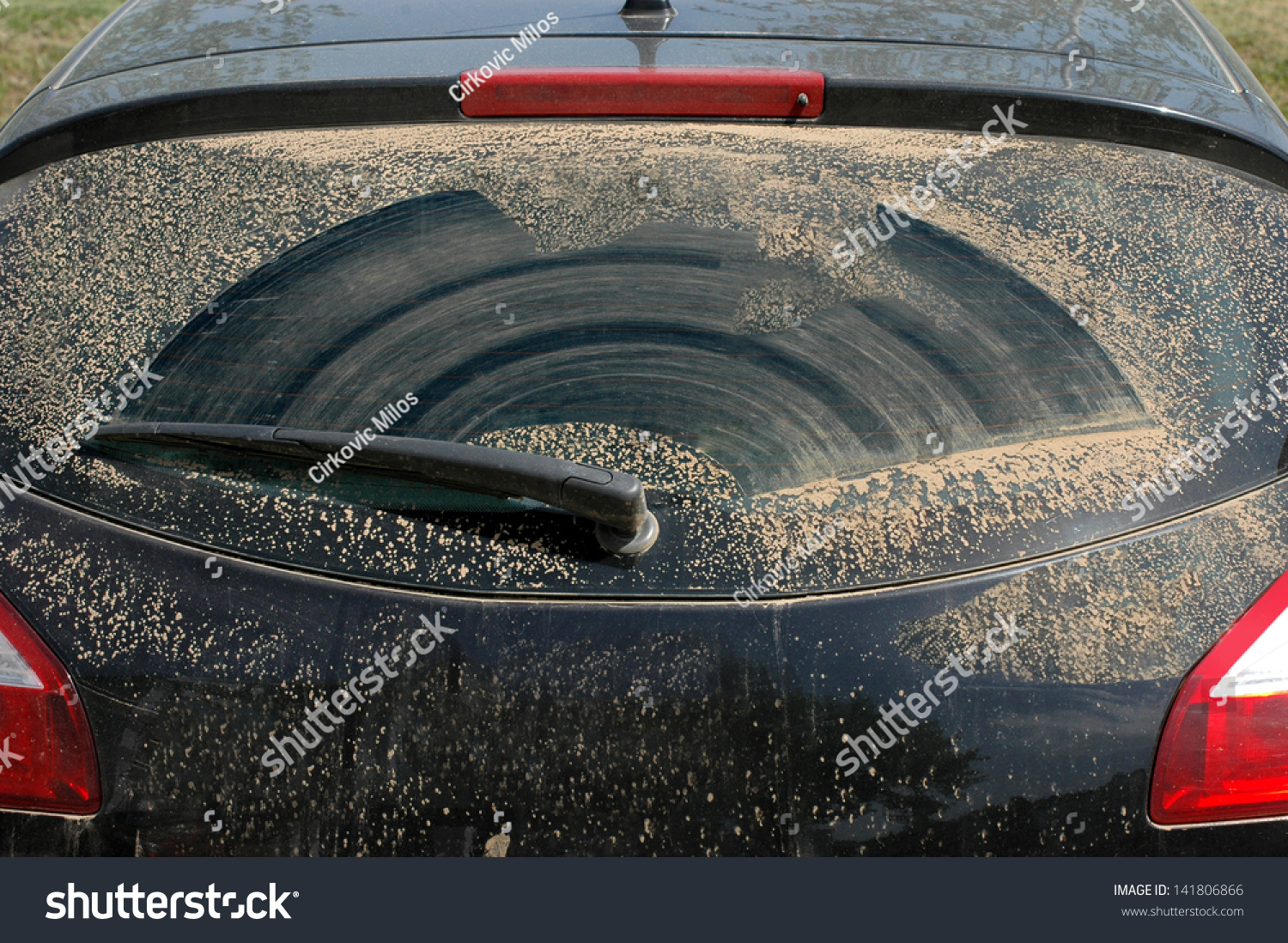 Dirty rear windshield of a rally car with wiper Dirty rear windshield of a rally car with wiper