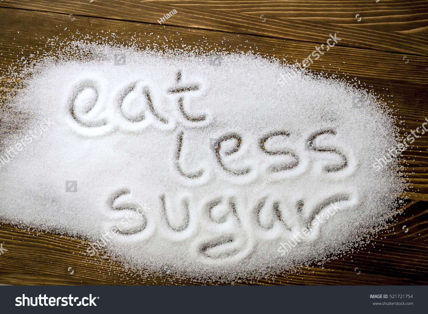 EAT LESS SUGAR written on brown wooden table Health concept EAT LESS SUGAR written on brown wooden table Health concept