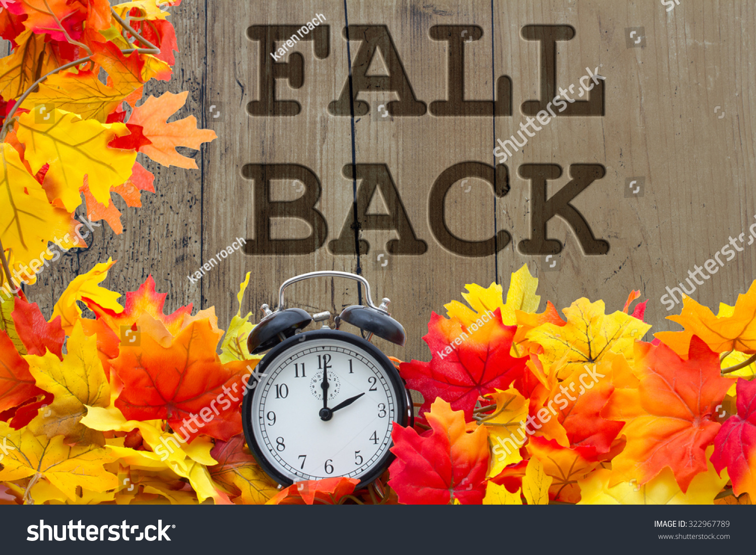 fall-back-time-change-autumn-leaves-and-alarm-clock-with-grunge-wood