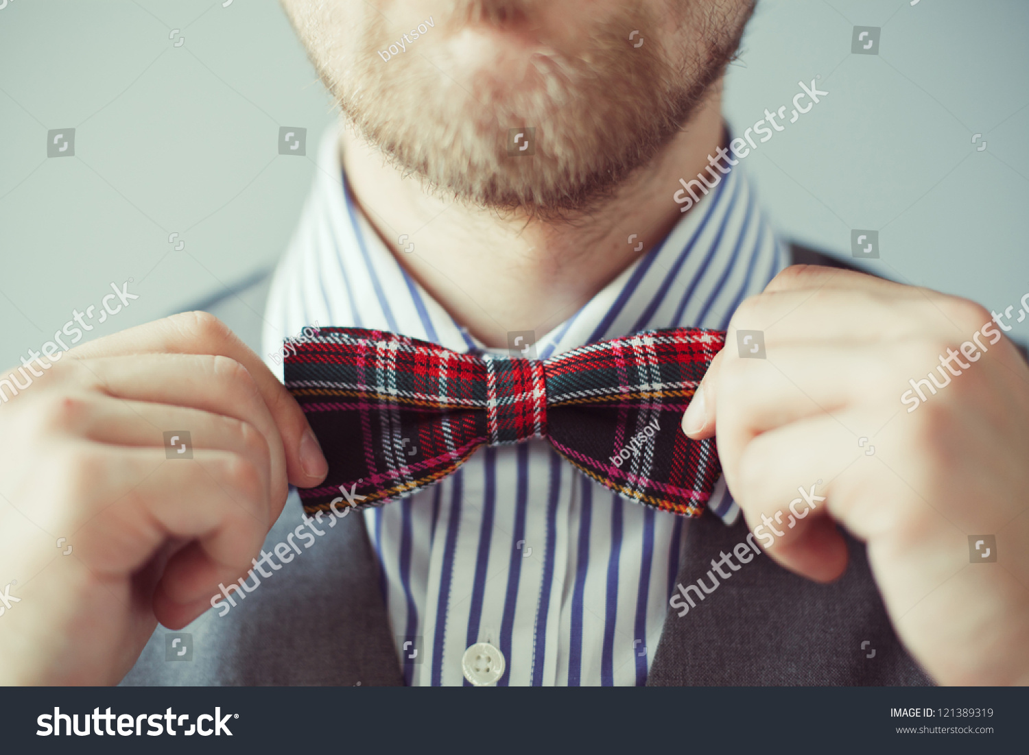 Fashion Photo Of A Man With Beard Correcting His Bowtie