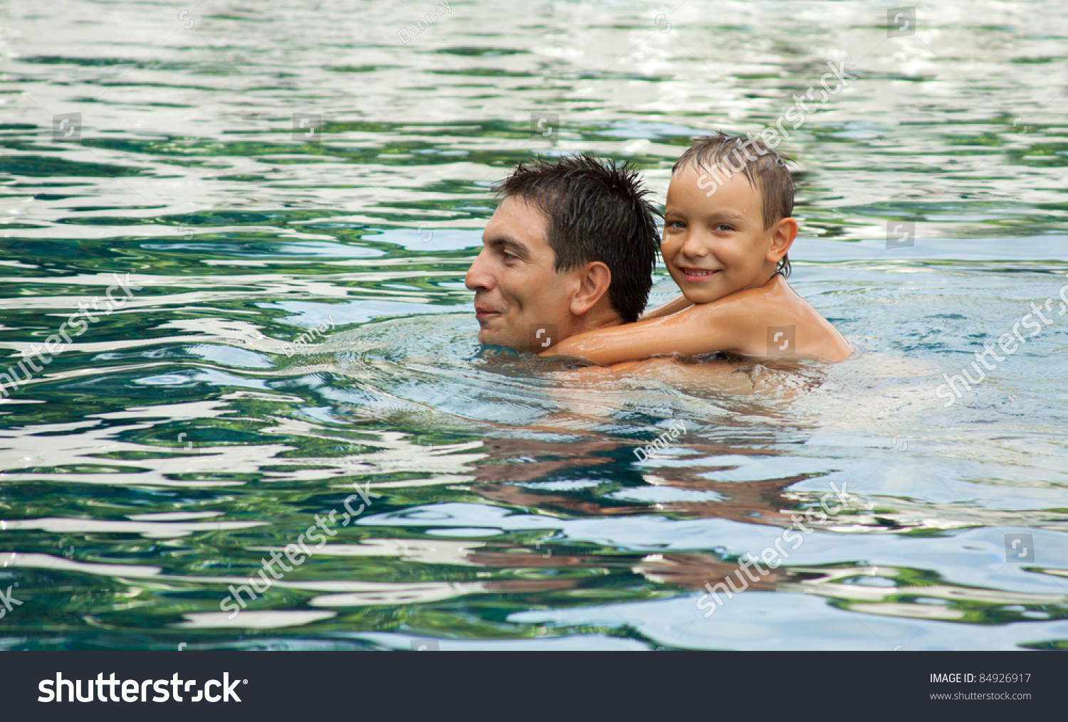 Father And Son Playing In A Swimming Pool Stock Photo