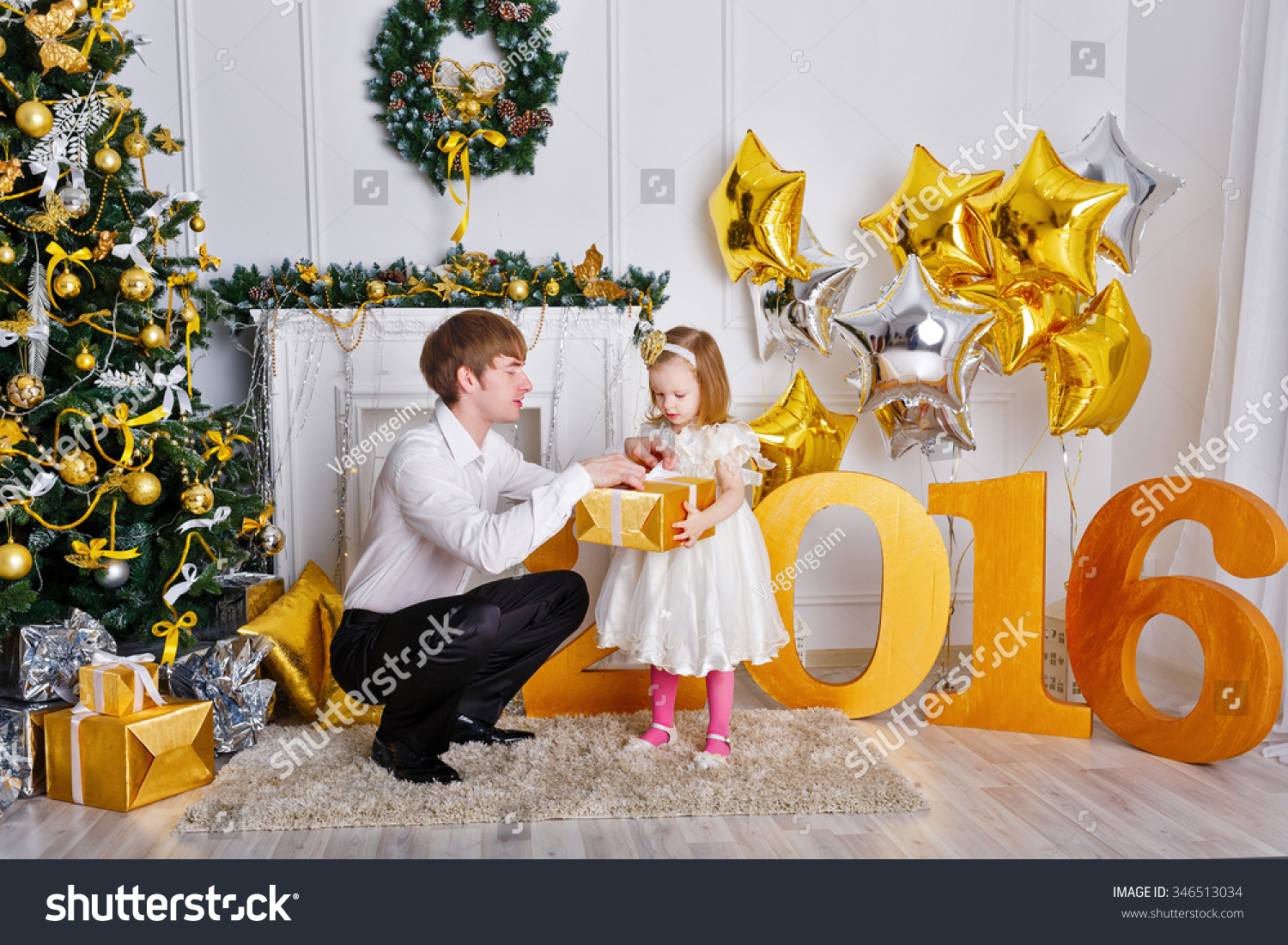 Father gives his daughter a gift for the New Year 2016 The concept of celebration and fun Family happiness Childhood Father gives his daughter a gift for the New Year 2016 The concept of celebration and fun Family happiness Childhood