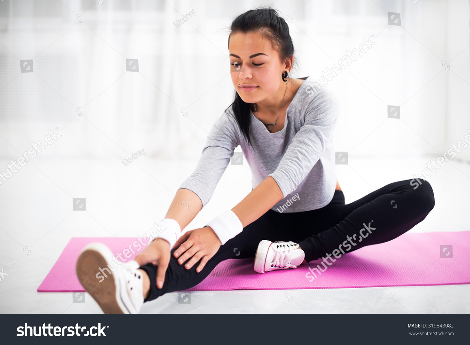 Fit Woman Doing Aerobics Gymnastics Stretching Exercises Her Leg And Back To Warm Up At Home On 