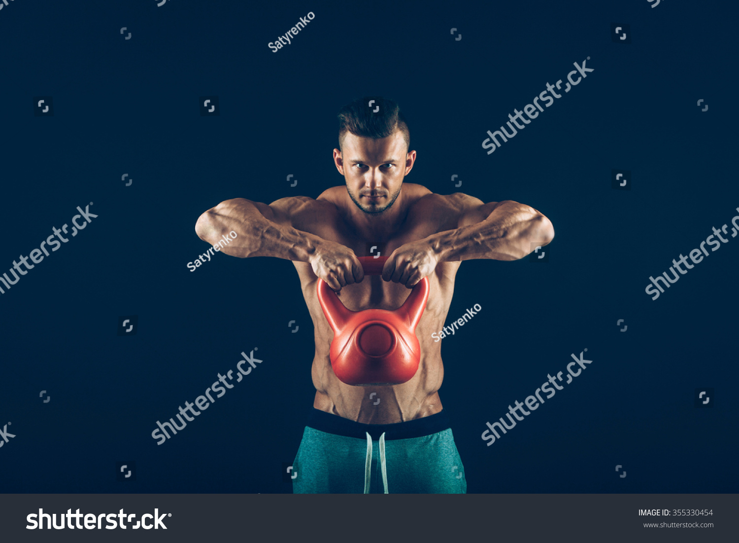 Fitness man doing a weight training by lifting a heavy kettlebell Fitness man doing a weight training by lifting a heavy kettlebell