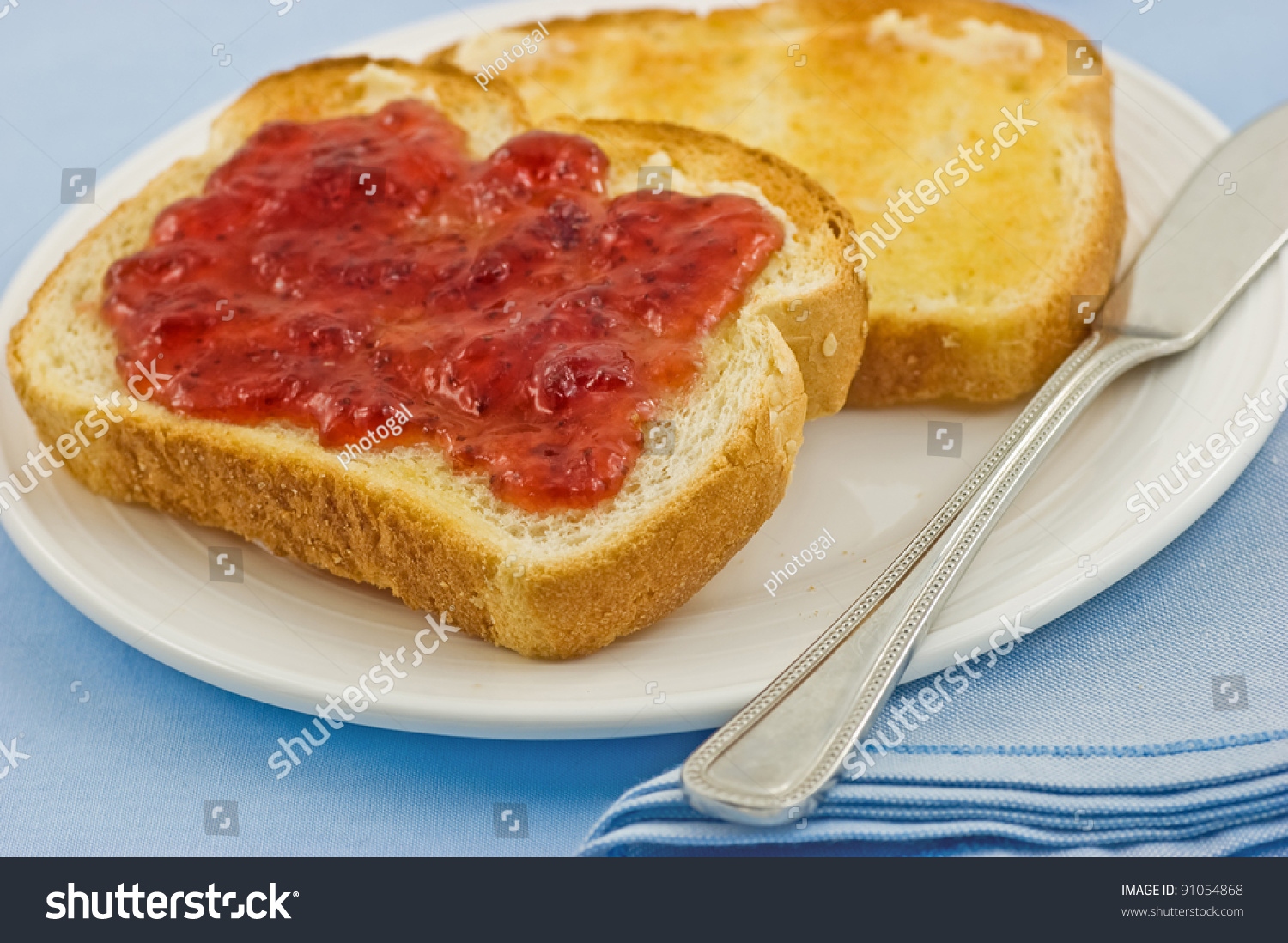 stock-photo-fresh-buttered-toast-with-strawberry-jam-on-blue-background-91054868.jpg