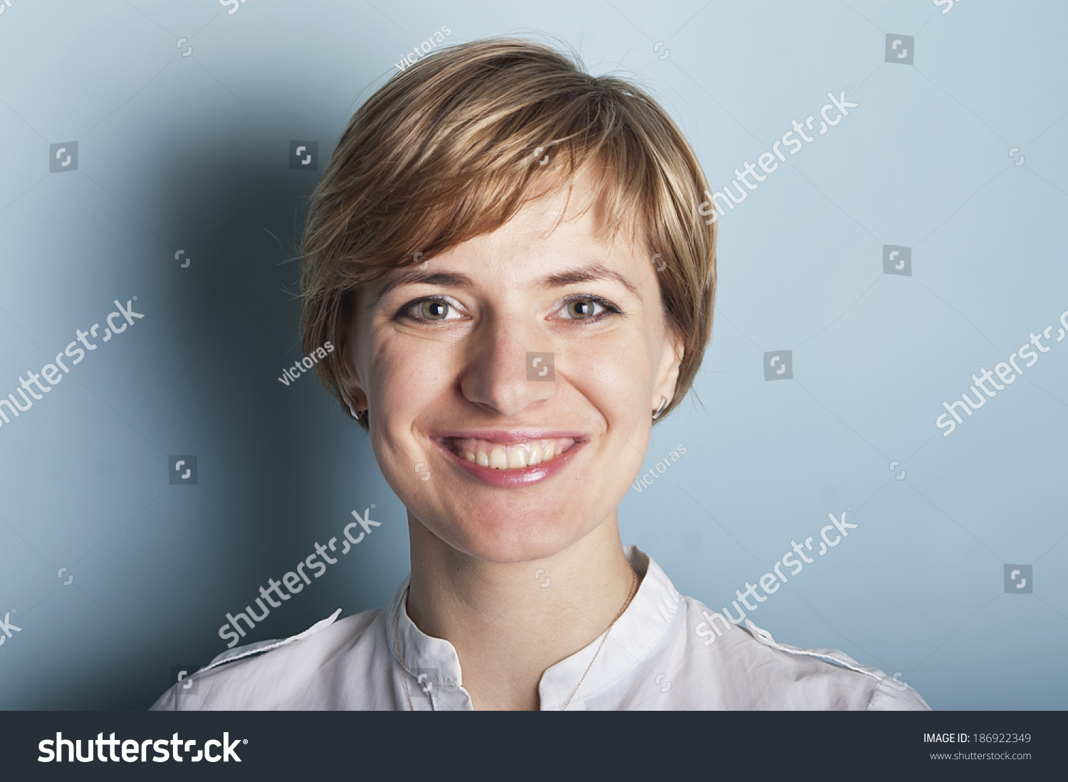 Frontal Portrait Of A Beautiful Joyful Woman, Studio Shot On Blue Stock 